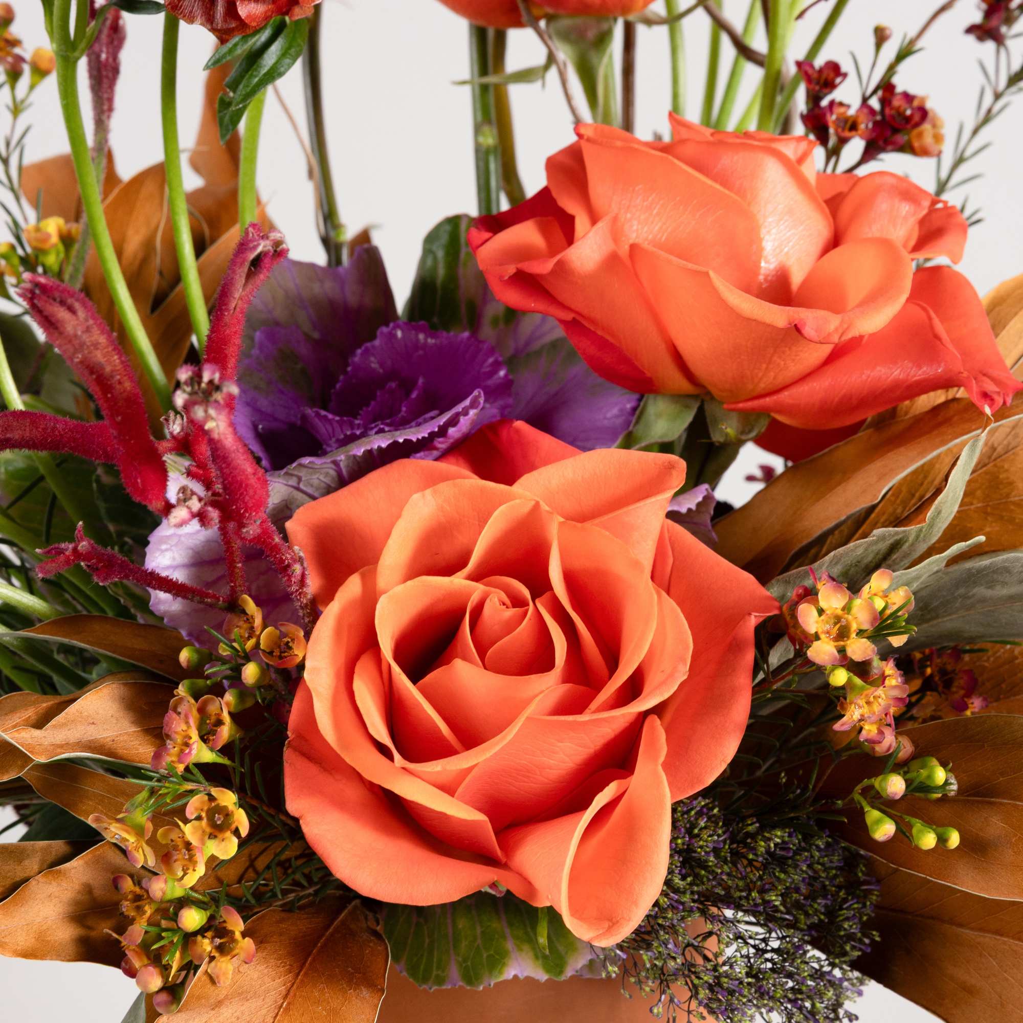 Orange roses and purple flowers in a peach box