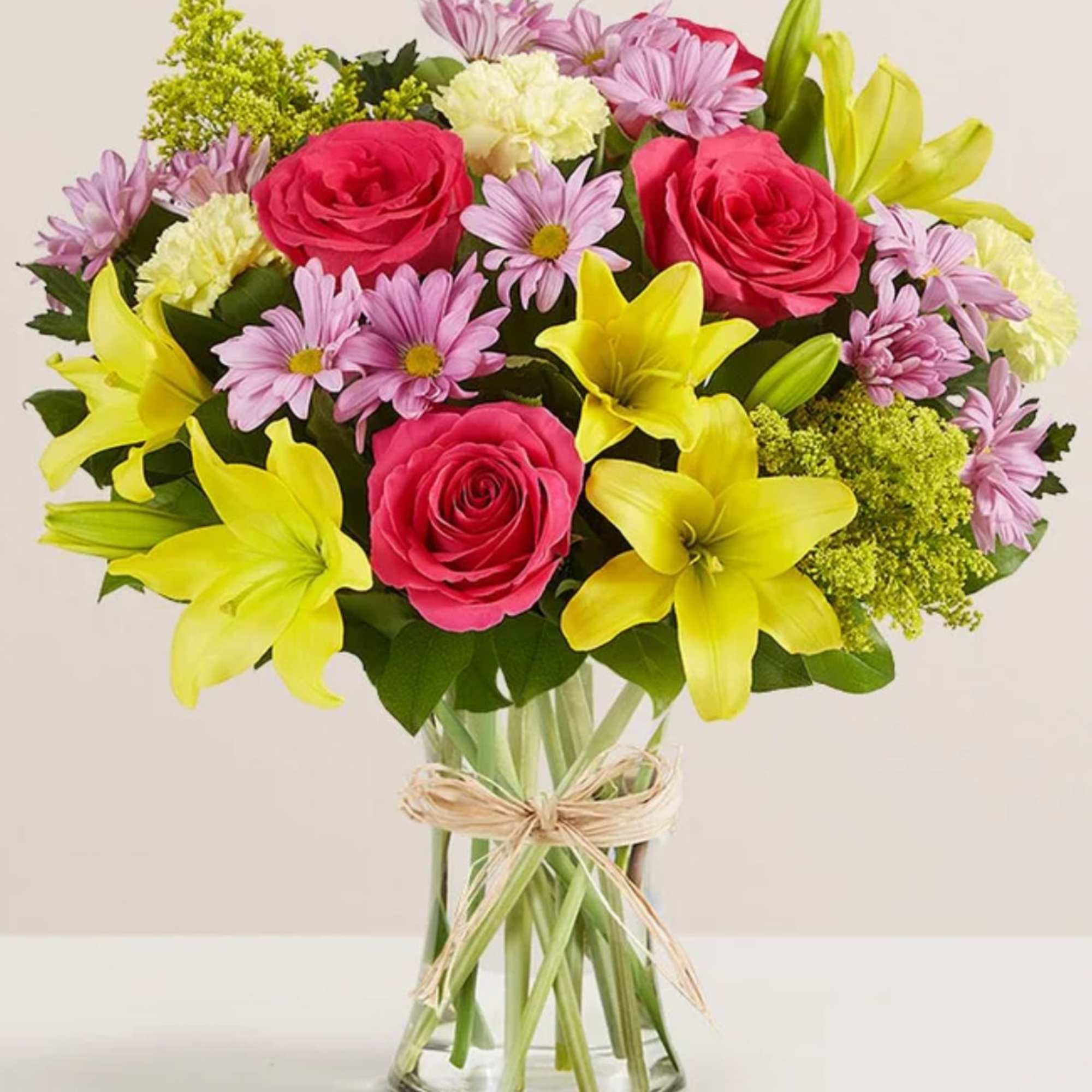 All-around arrangement with hot pink roses; yellow Asiatic lilies and carnations; lavender