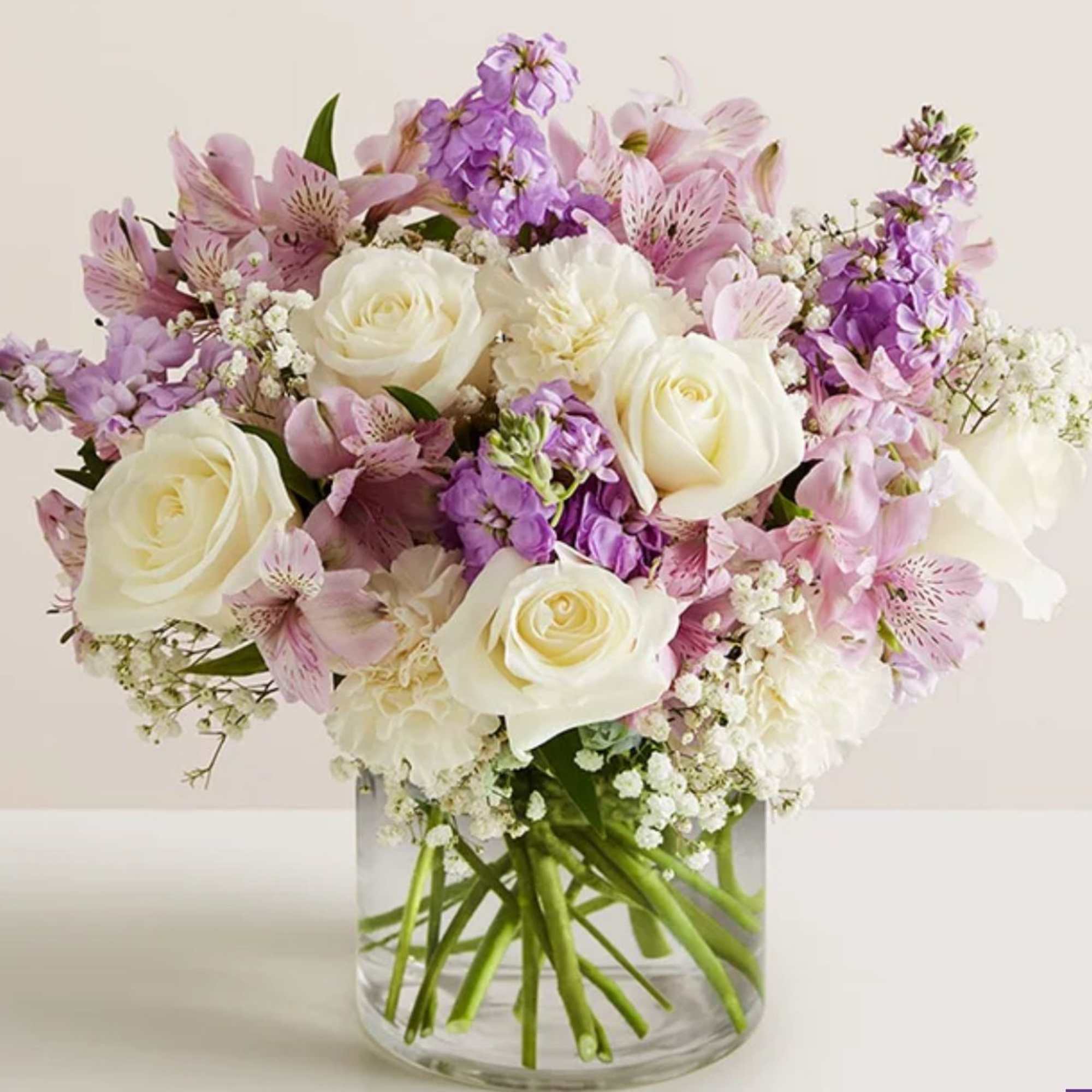 All-around arrangement with white roses and carnations; lavender Peruvian lilies (alstroemeria) and