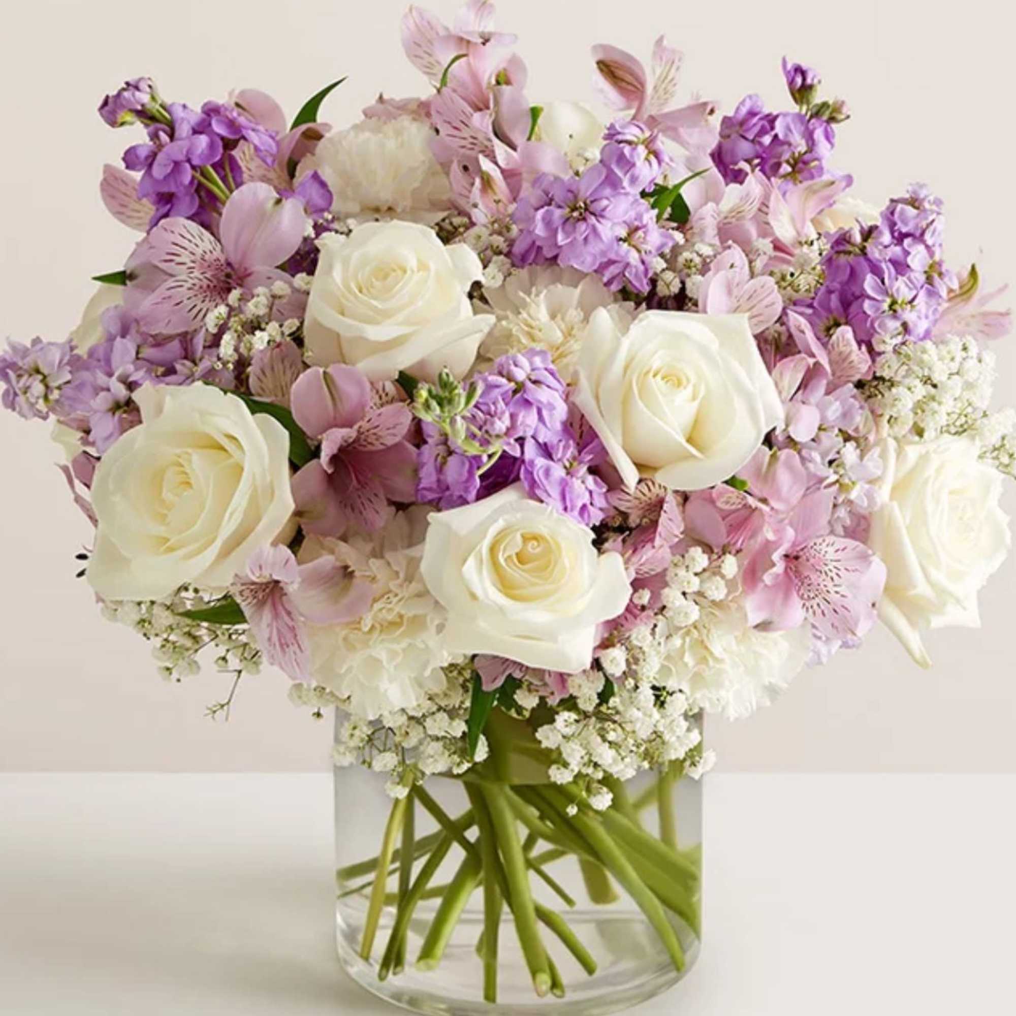 All-around arrangement with white roses and carnations; lavender Peruvian lilies (alstroemeria) and