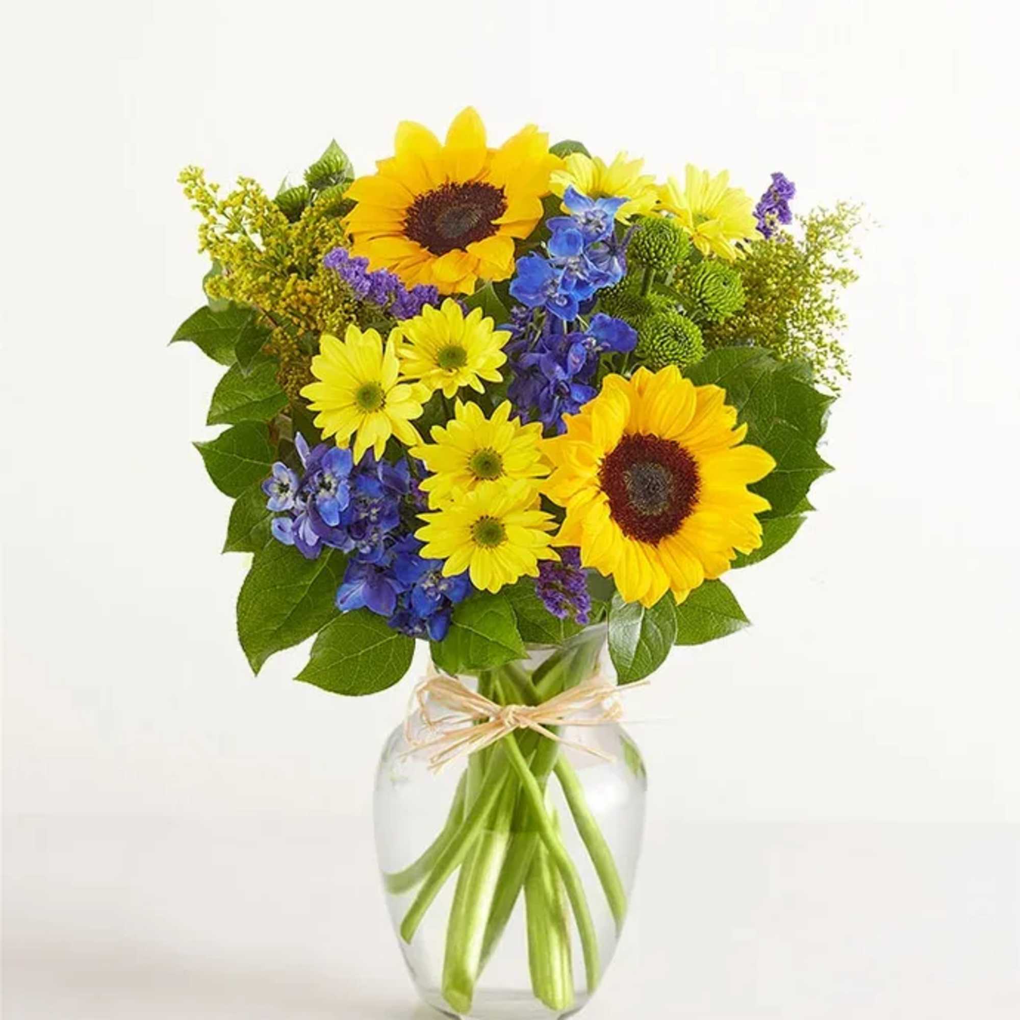 All-around arrangement with sunflowers, blue delphiniums, yellow daisy poms, green button poms