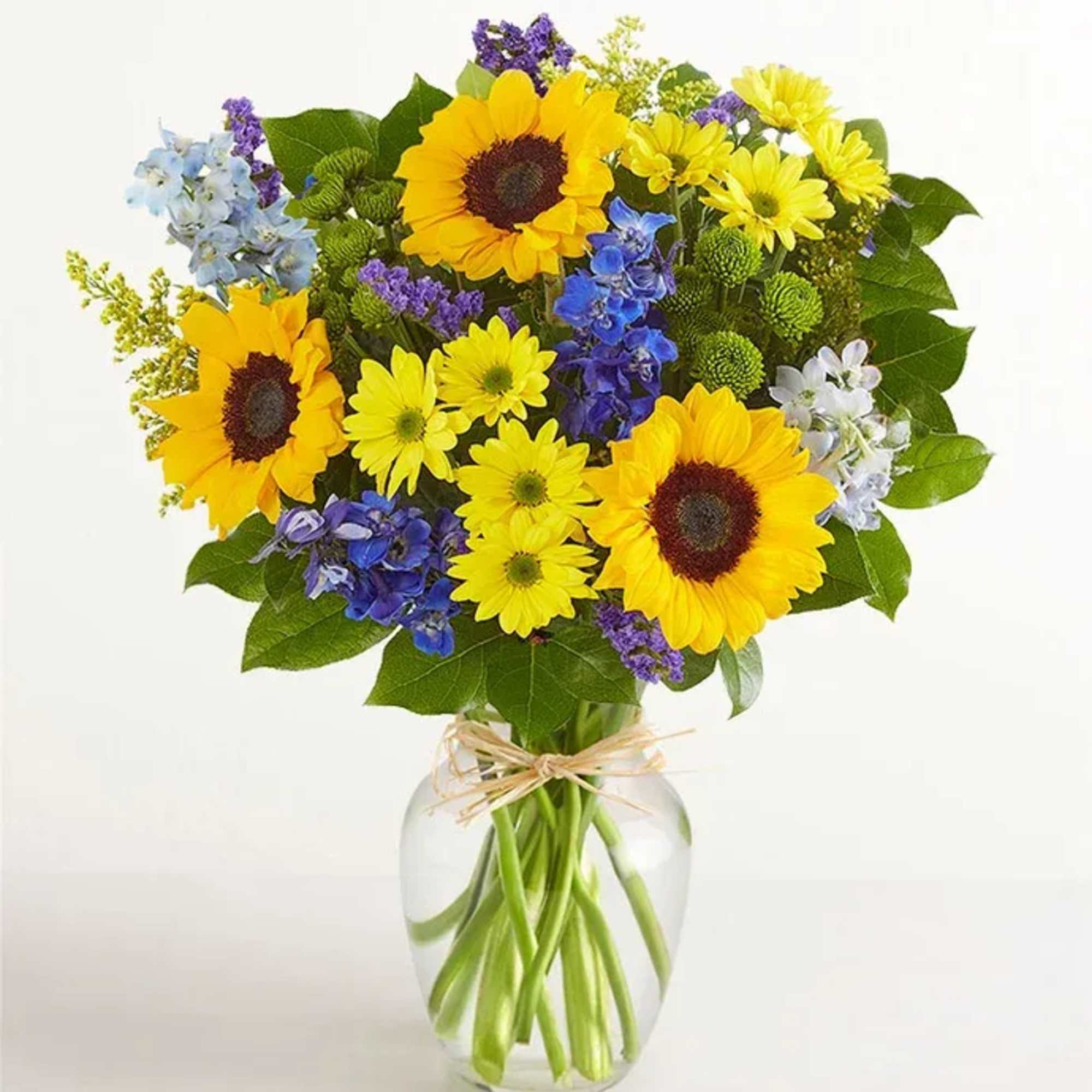 All-around arrangement with sunflowers, blue delphiniums, yellow daisy poms, green button poms