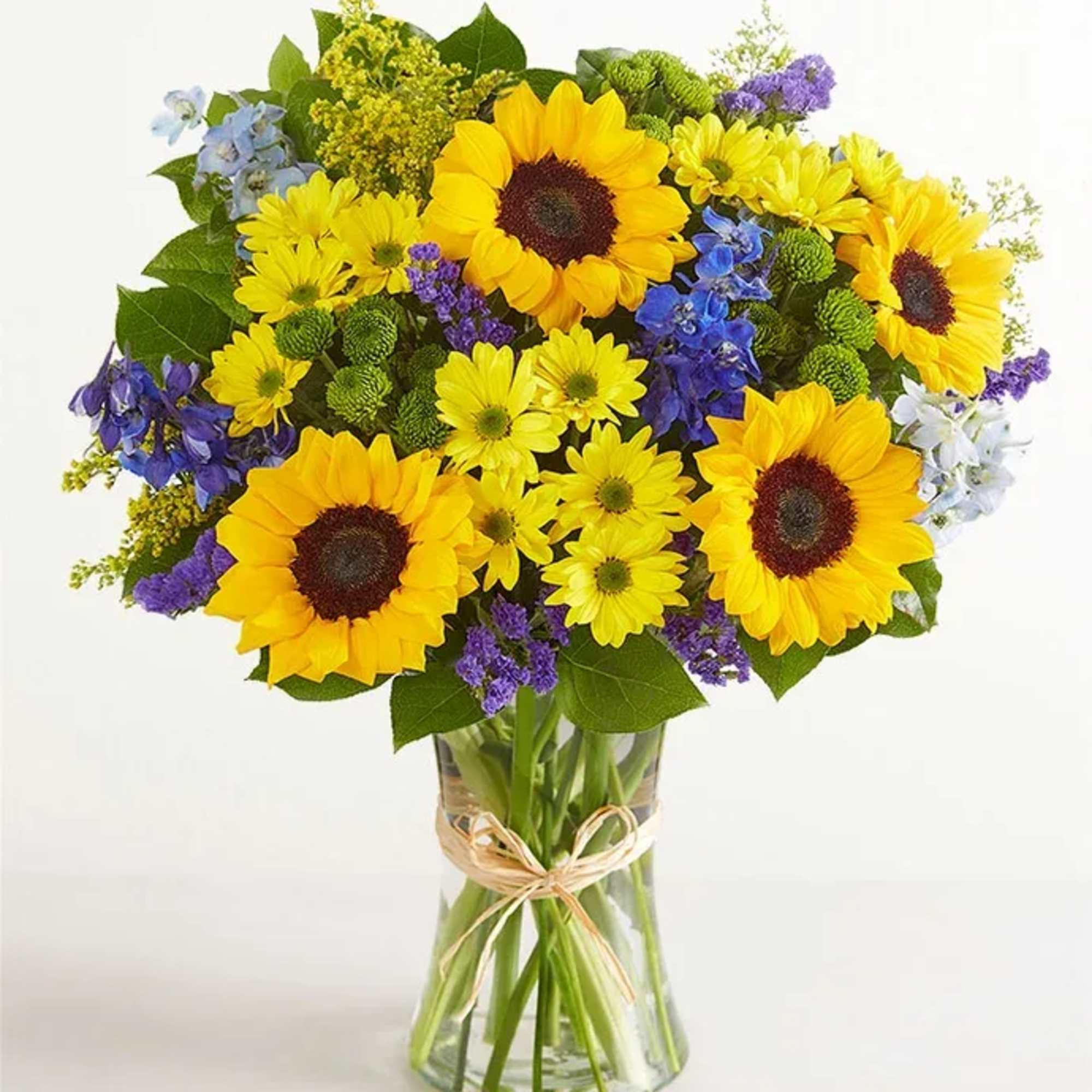 All-around arrangement with sunflowers, blue delphiniums, yellow daisy poms, green button poms