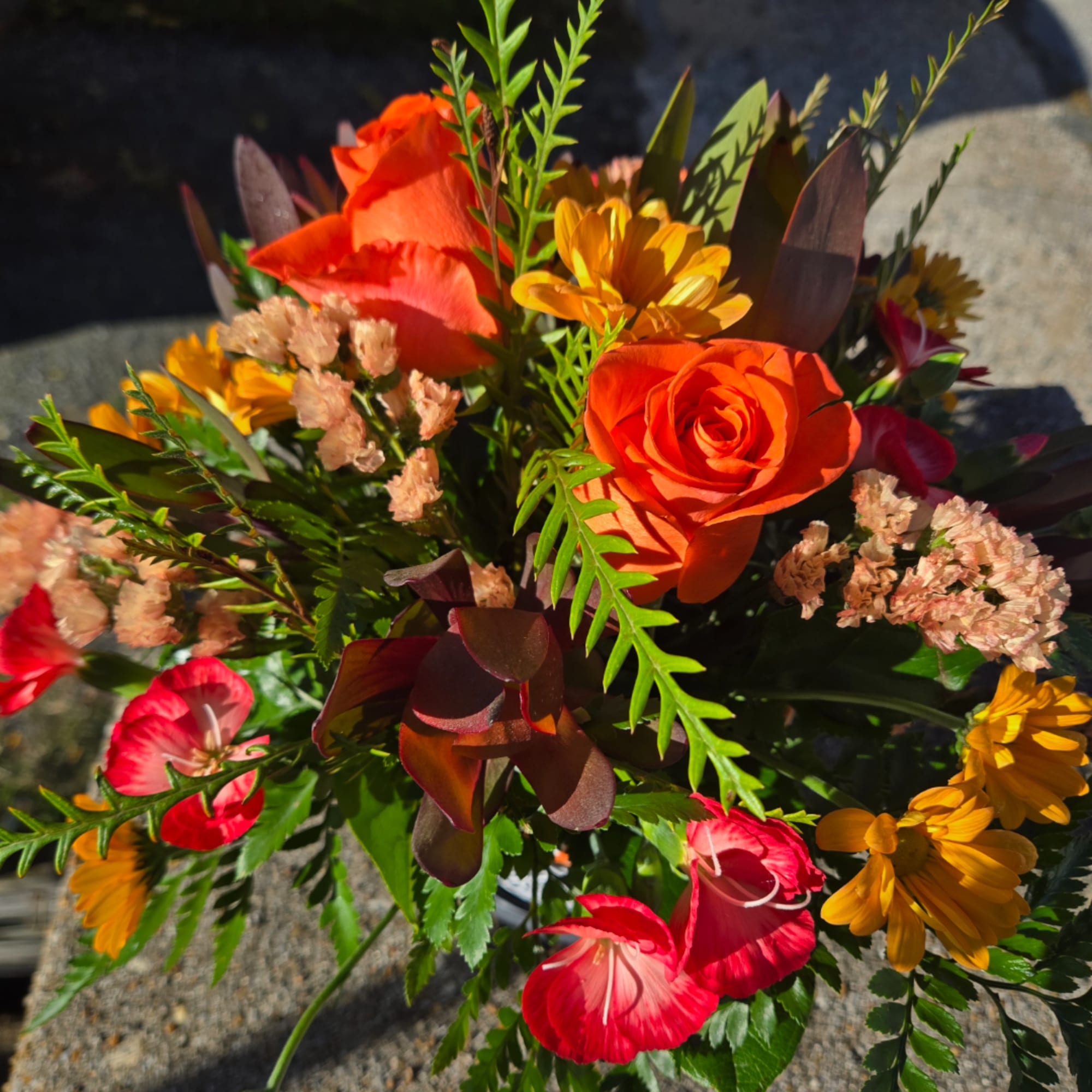 Bright mixed bouquet with orange roses and yellow and red blooms