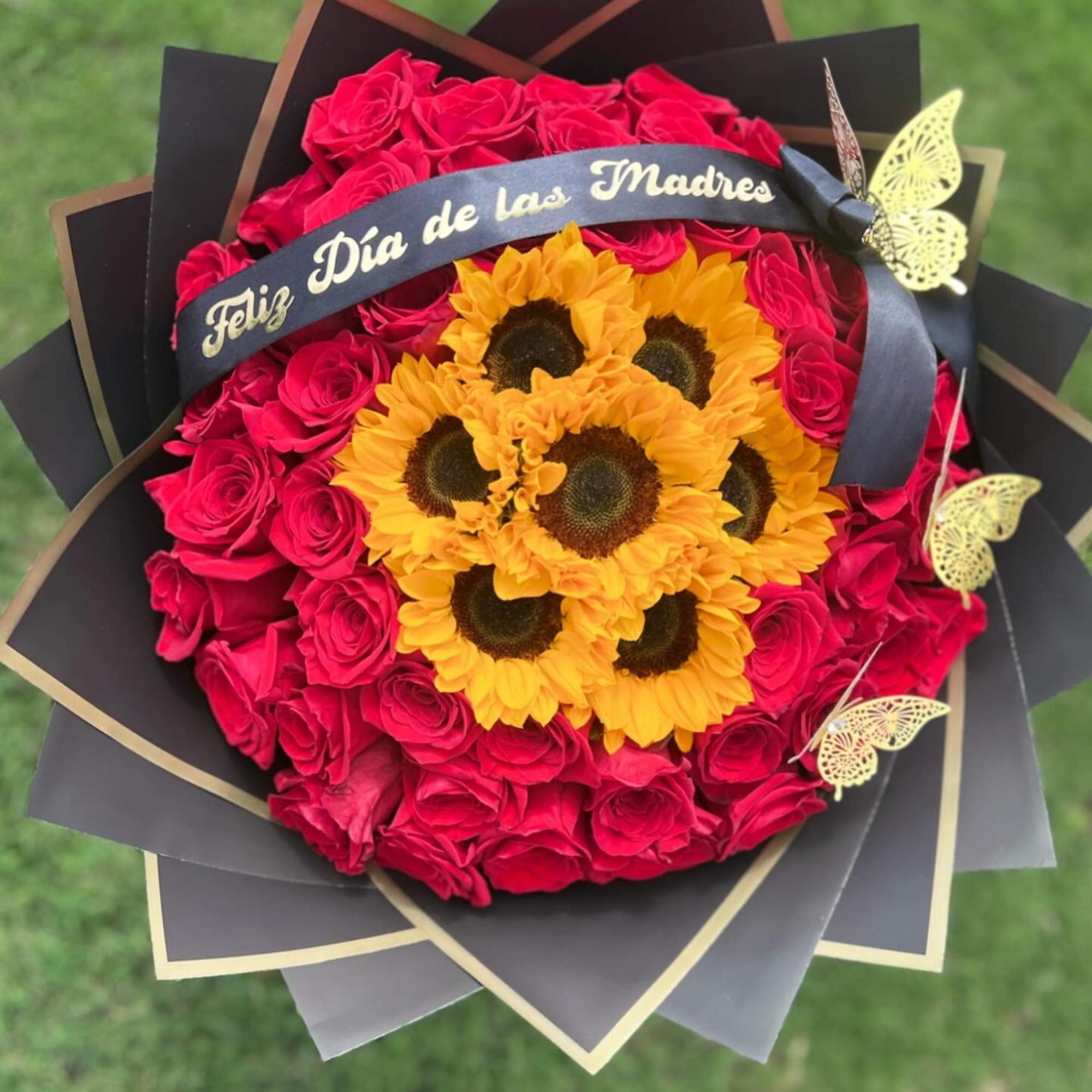 Bouquet of red roses and yellow sunflowers with a Mother's Day ribbon