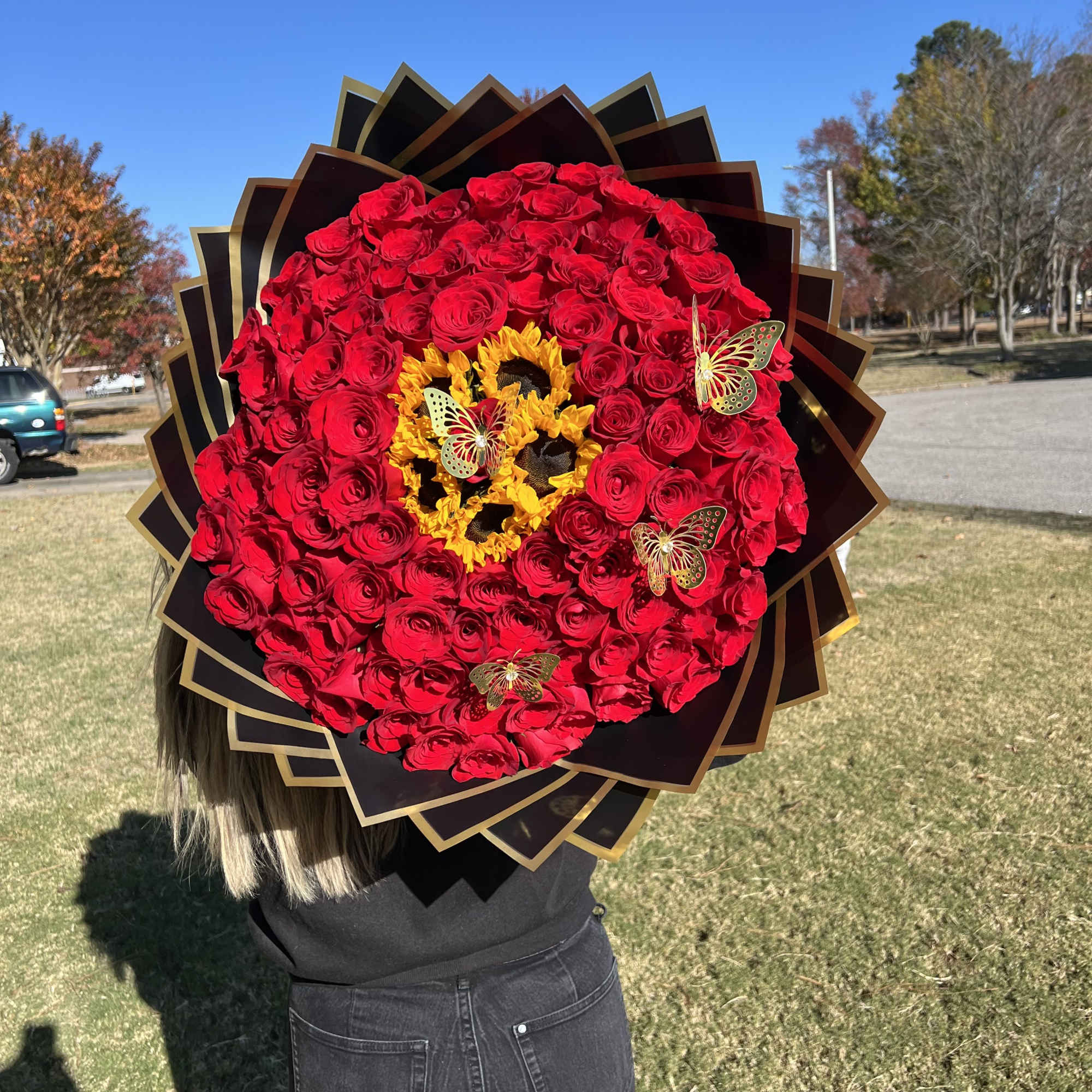 Large bouquet of red roses with sunflowers and butterfly accents