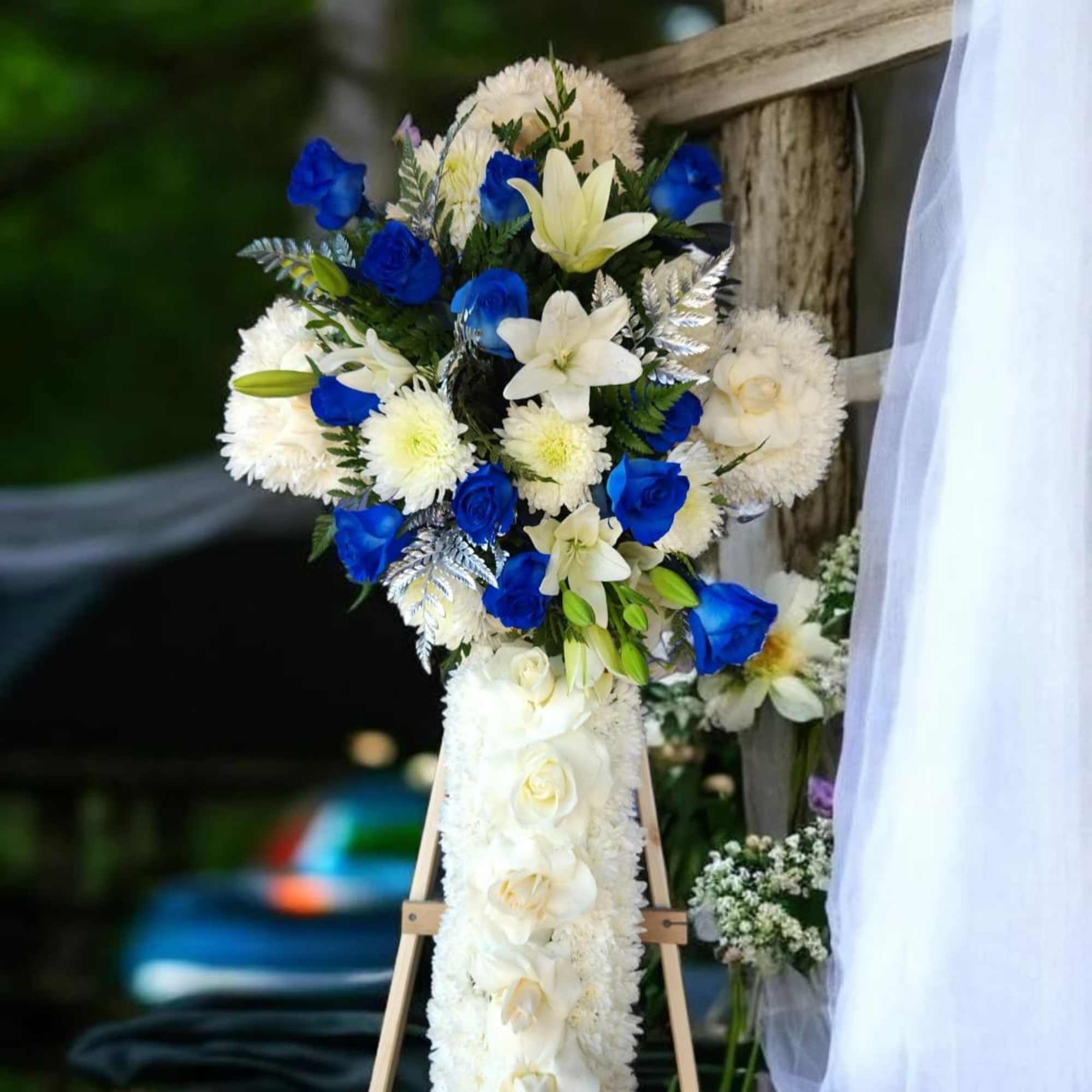 White and blue floral standing arrangement on an easel
