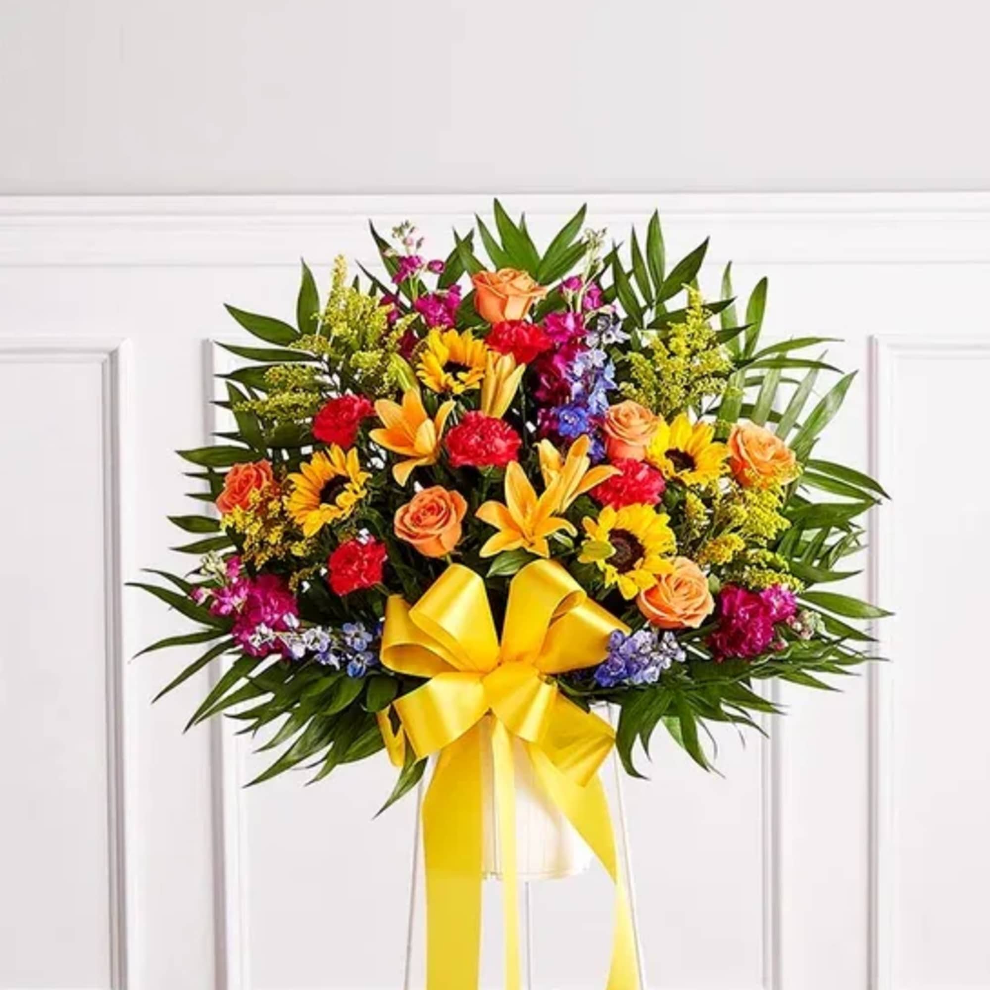 Colorful standing floral spray with a yellow ribbon bow