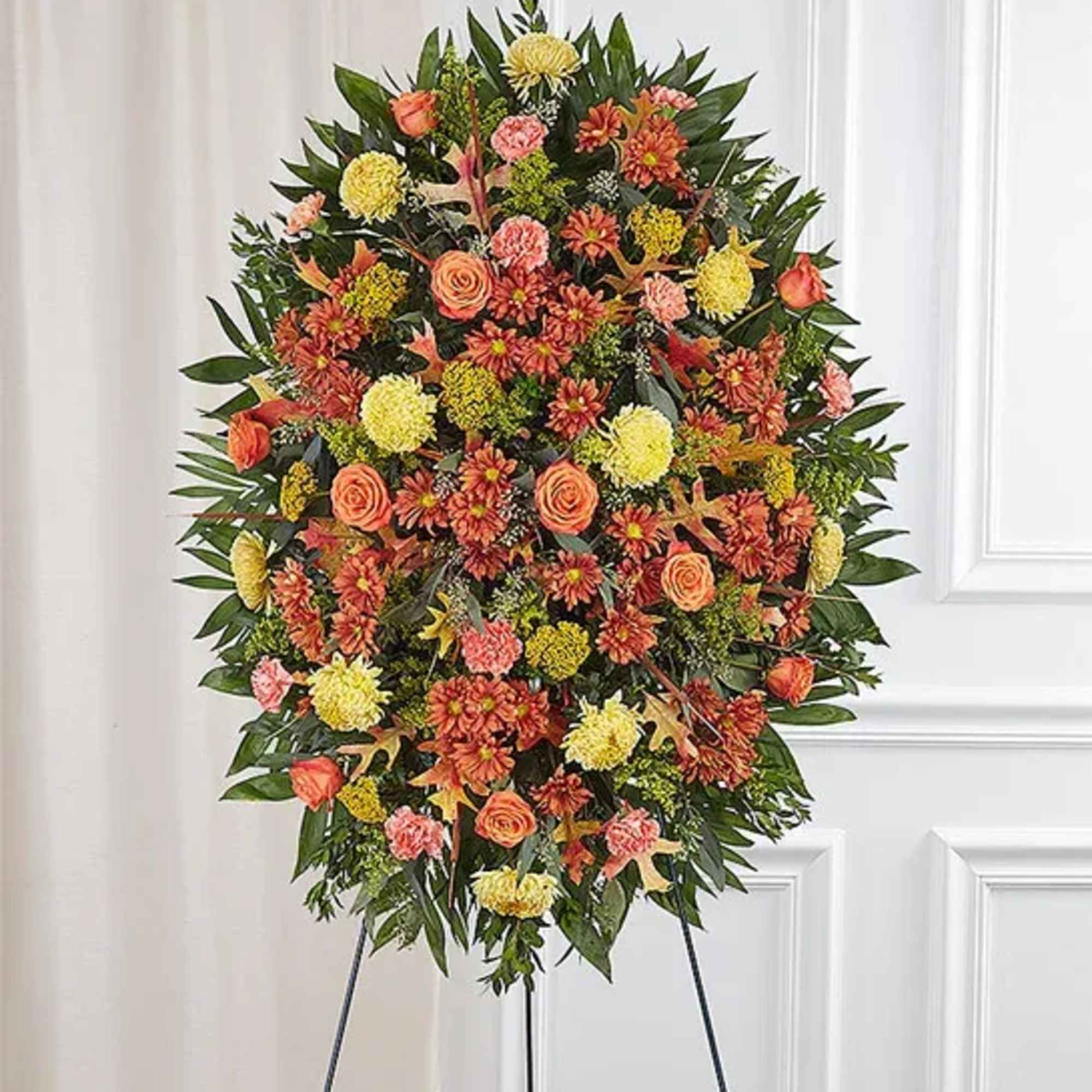 Large standing floral spray with orange, yellow, and pink blooms