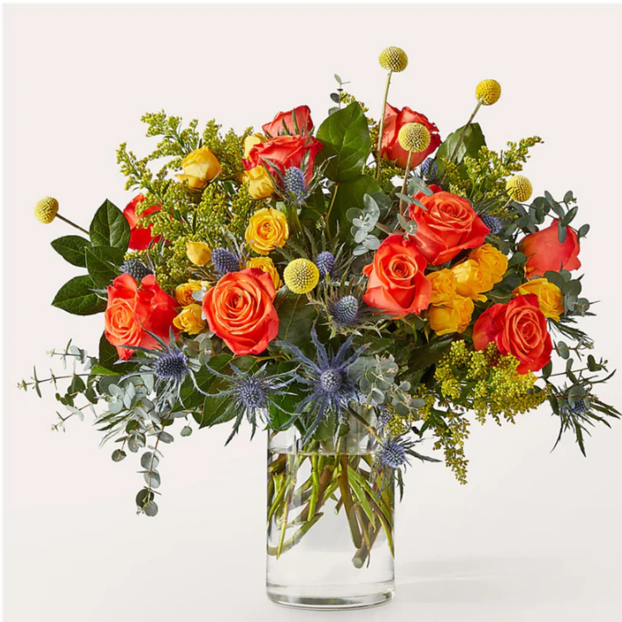 Mixed bouquet of orange and yellow roses in a clear glass vase