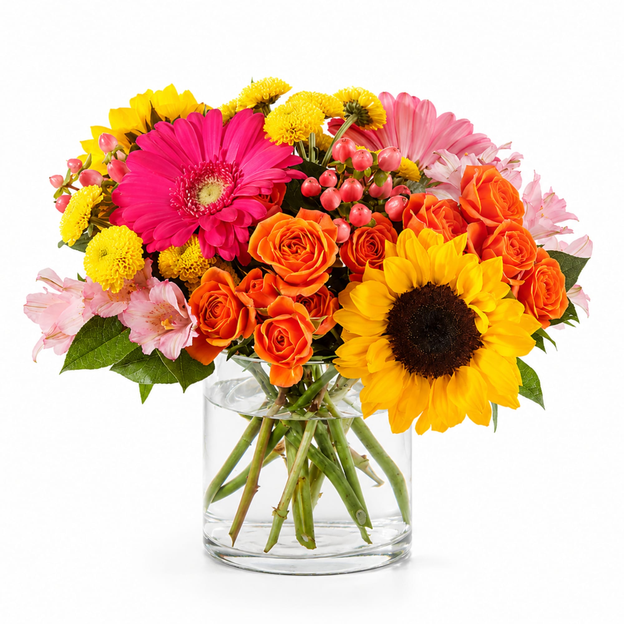 Bright mixed bouquet of roses, gerbera daisies, sunflowers, and mums in a glass vase