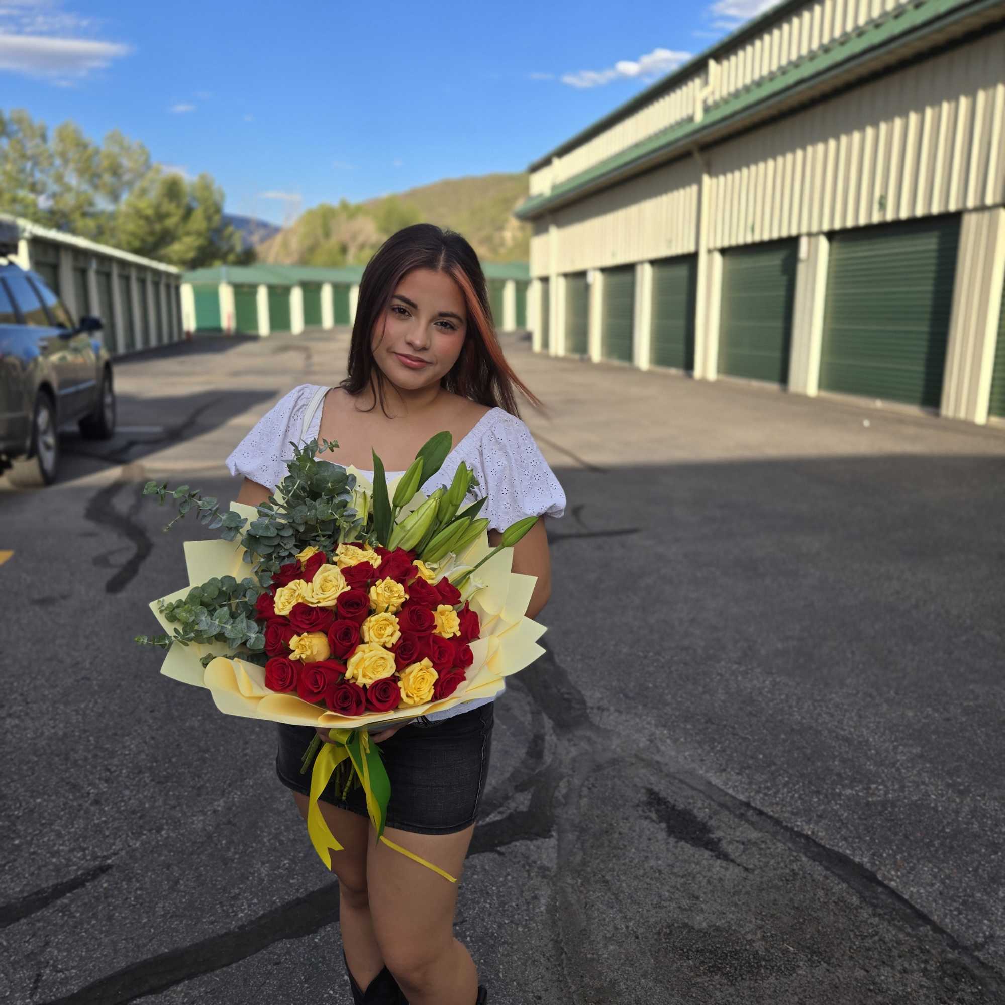 Bouquet of red and yellow roses with lilies and greenery