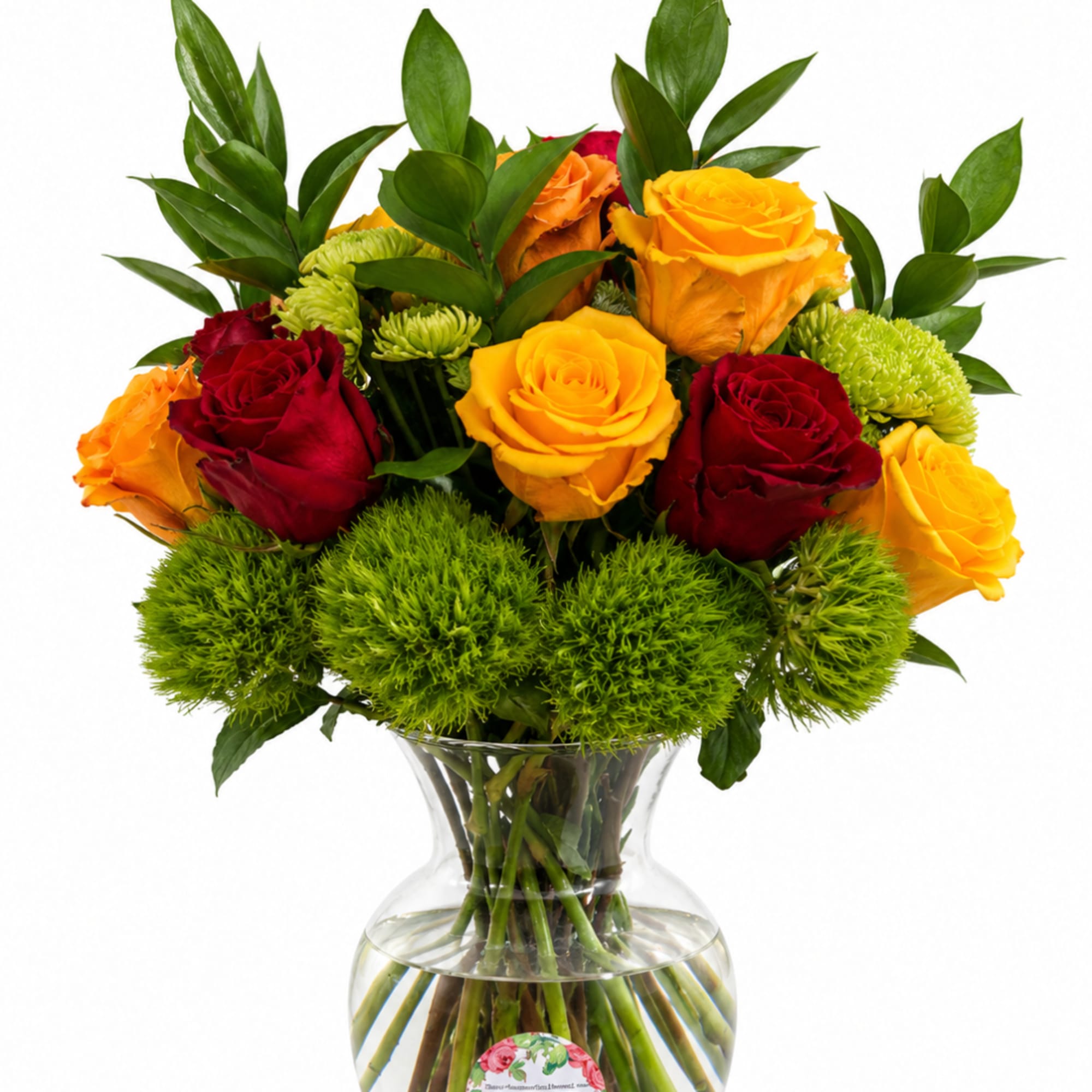 Bouquet of red and yellow roses with green pom-pom flowers in a clear glass vase