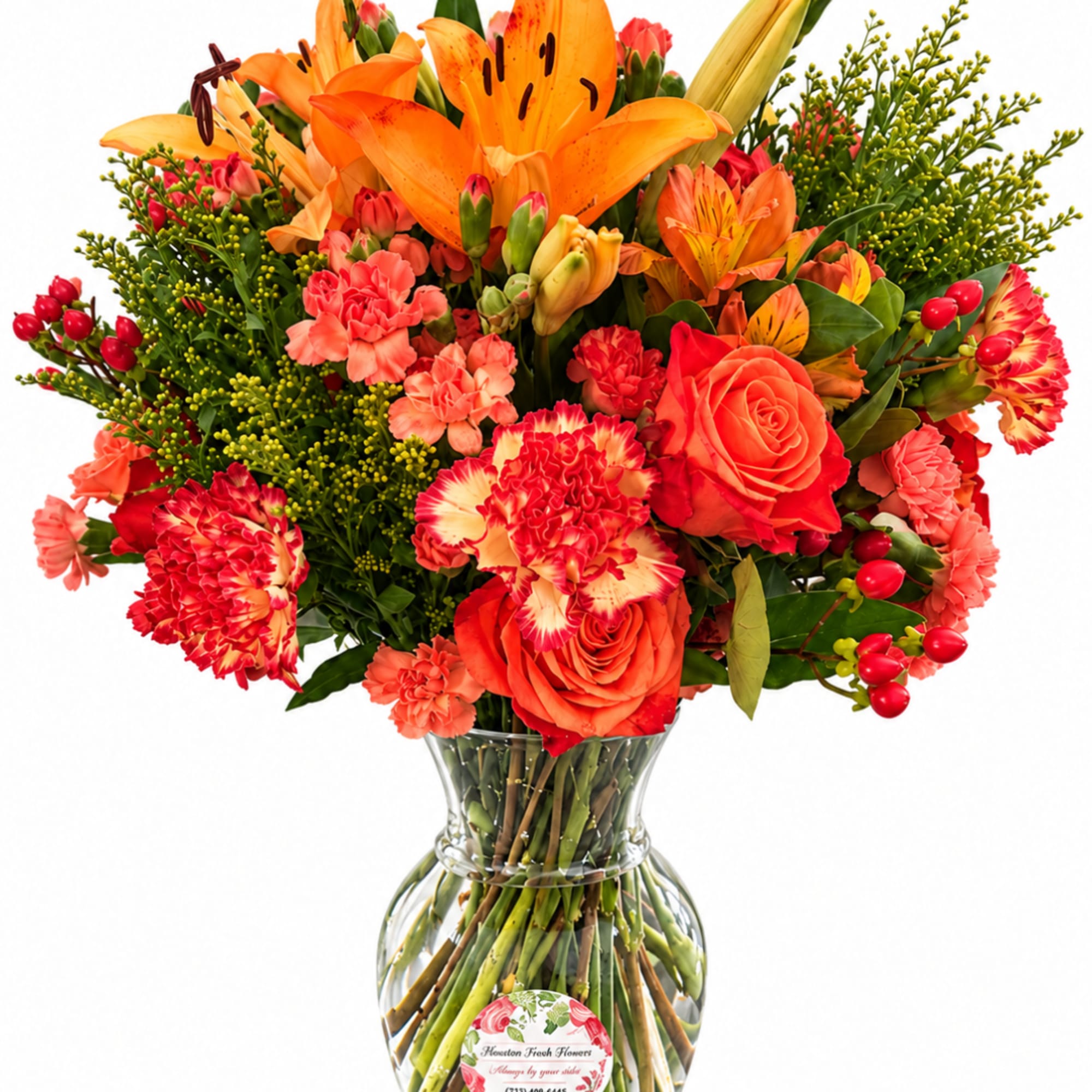 Orange and red mixed bouquet in a clear glass vase