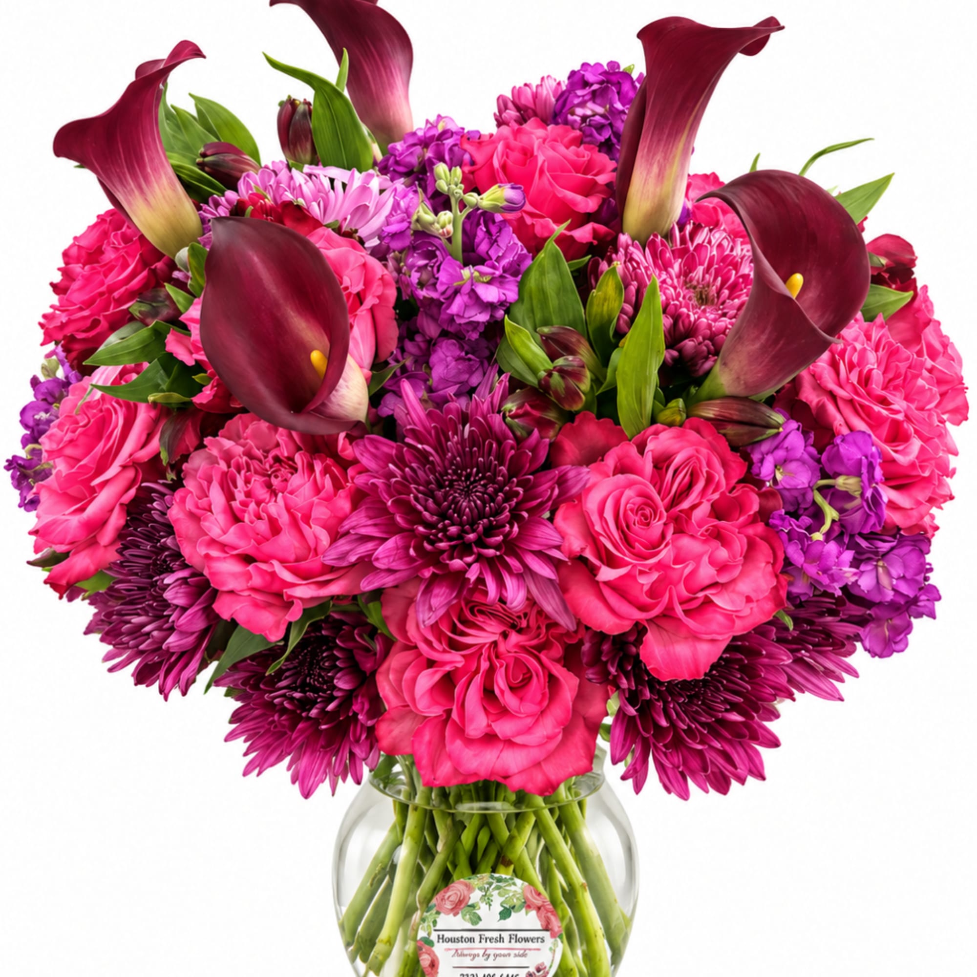 Pink and purple bouquet with calla lilies and roses in a glass vase