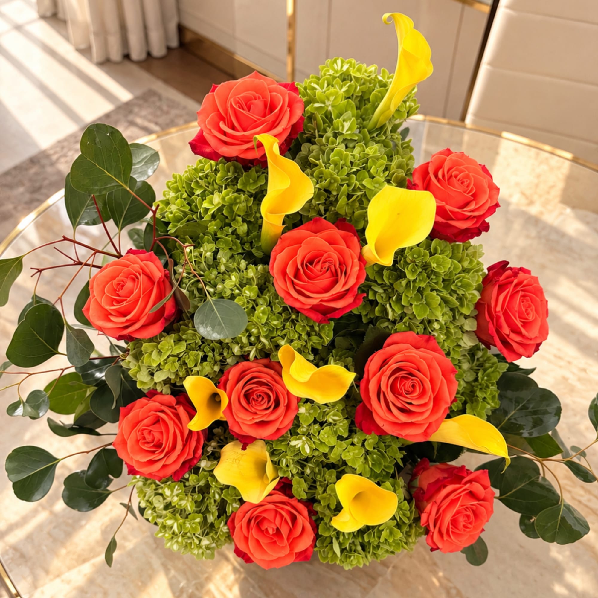 Red roses and yellow calla lilies in a compact green arrangement