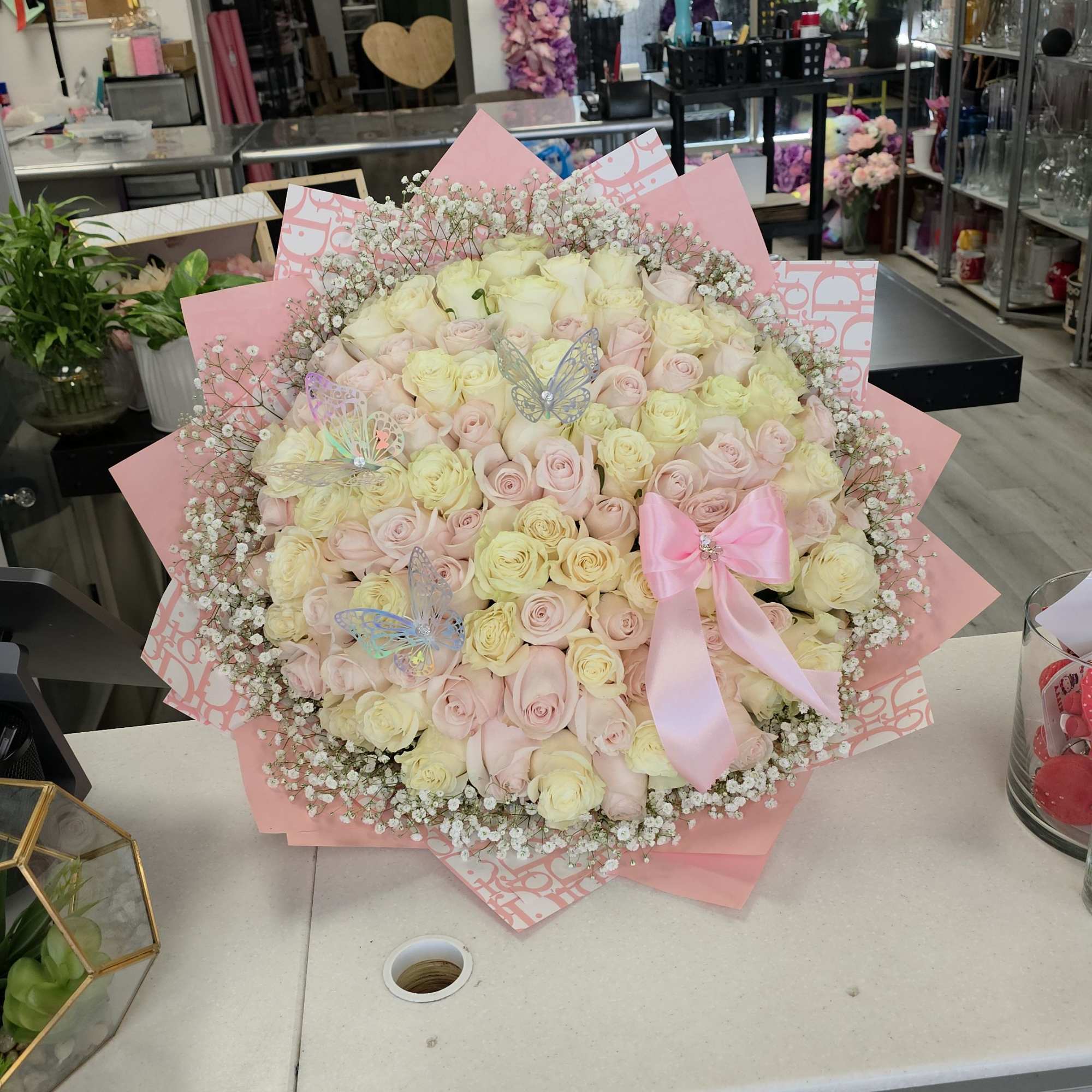 Large bouquet of pale pink and cream roses with a pink ribbon