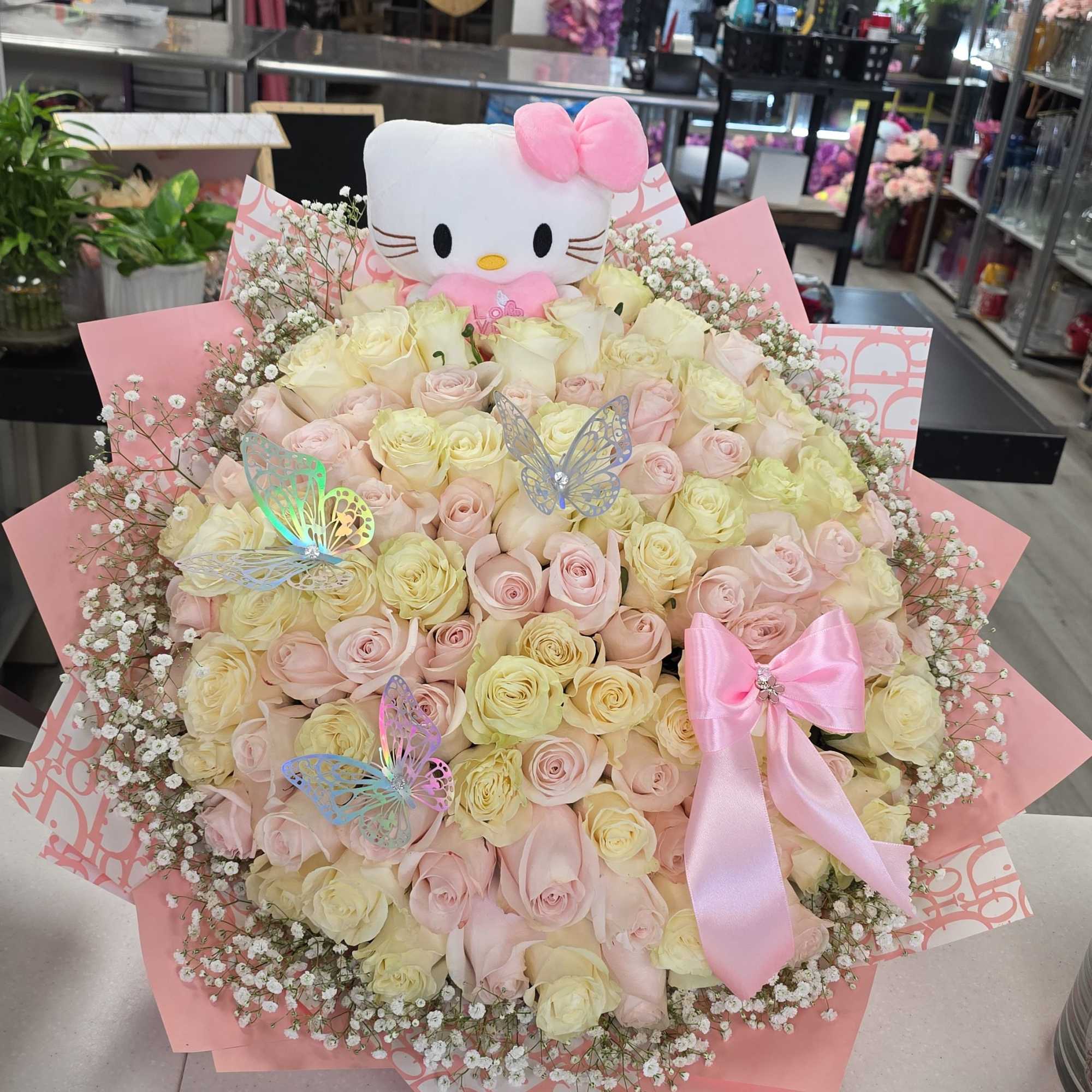 Bouquet of pale pink and cream roses with a Hello Kitty plush and pink ribbon