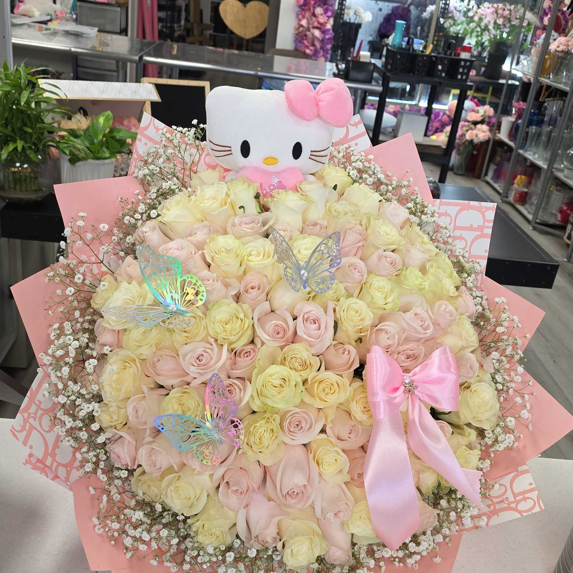 Large bouquet of pale pink and cream roses with a Hello Kitty plush and pink ribbon