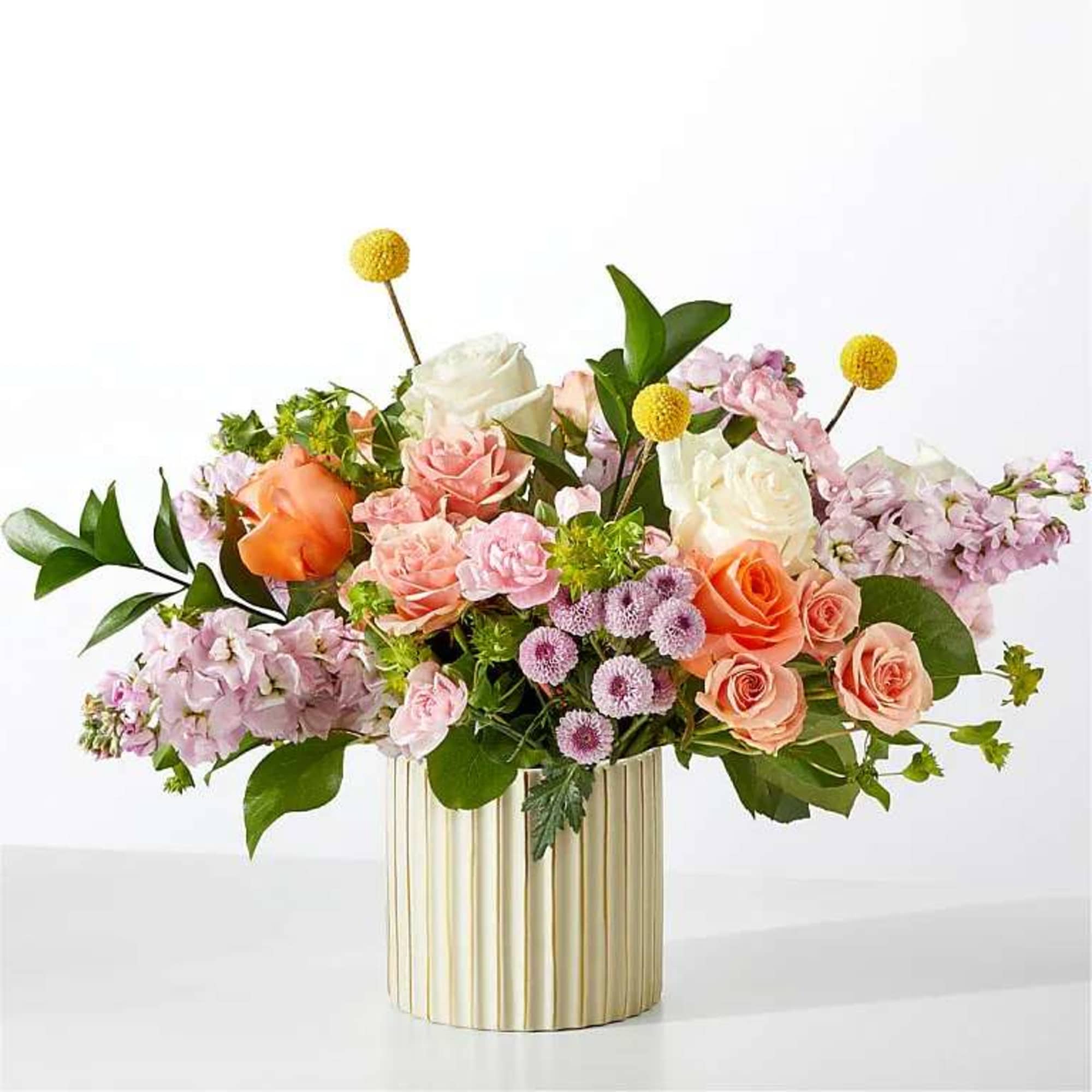 Mixed bouquet of roses and pastel flowers in a gold vase