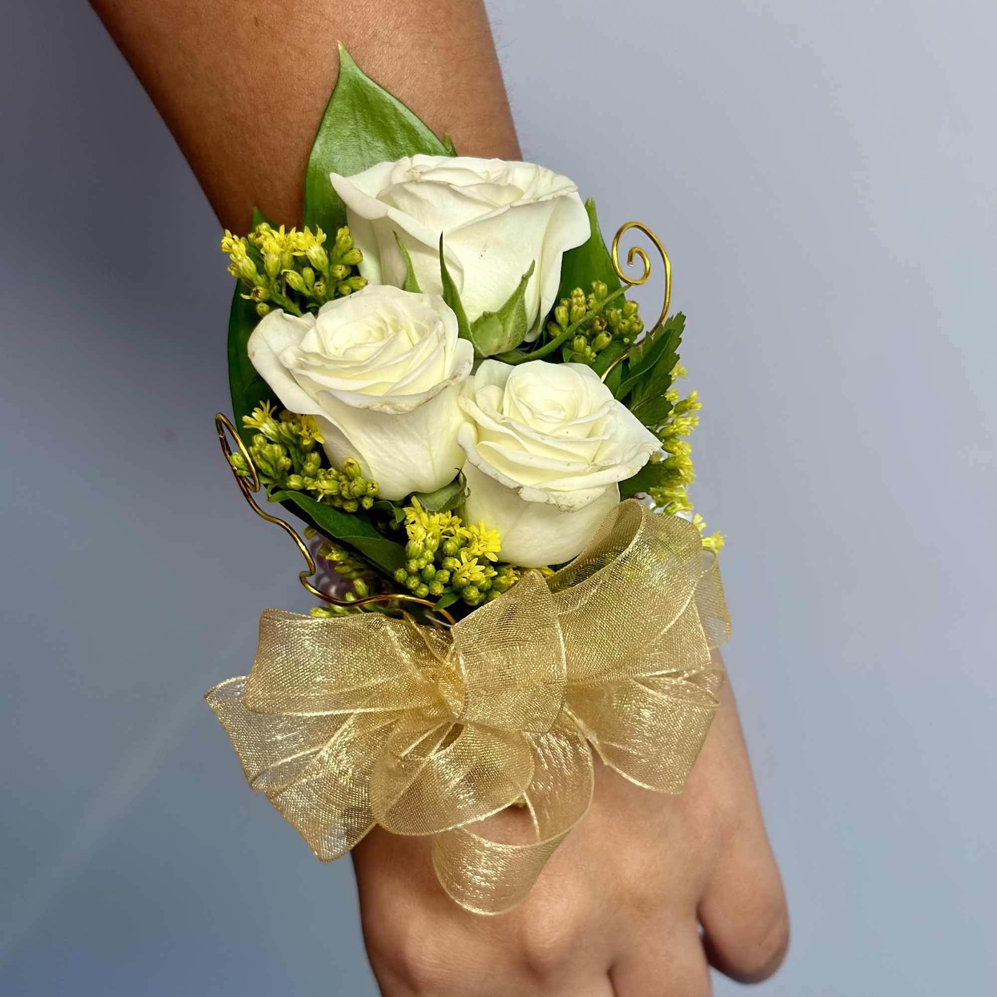 Lia Corsage made with white spray roses solidago and gold accent on