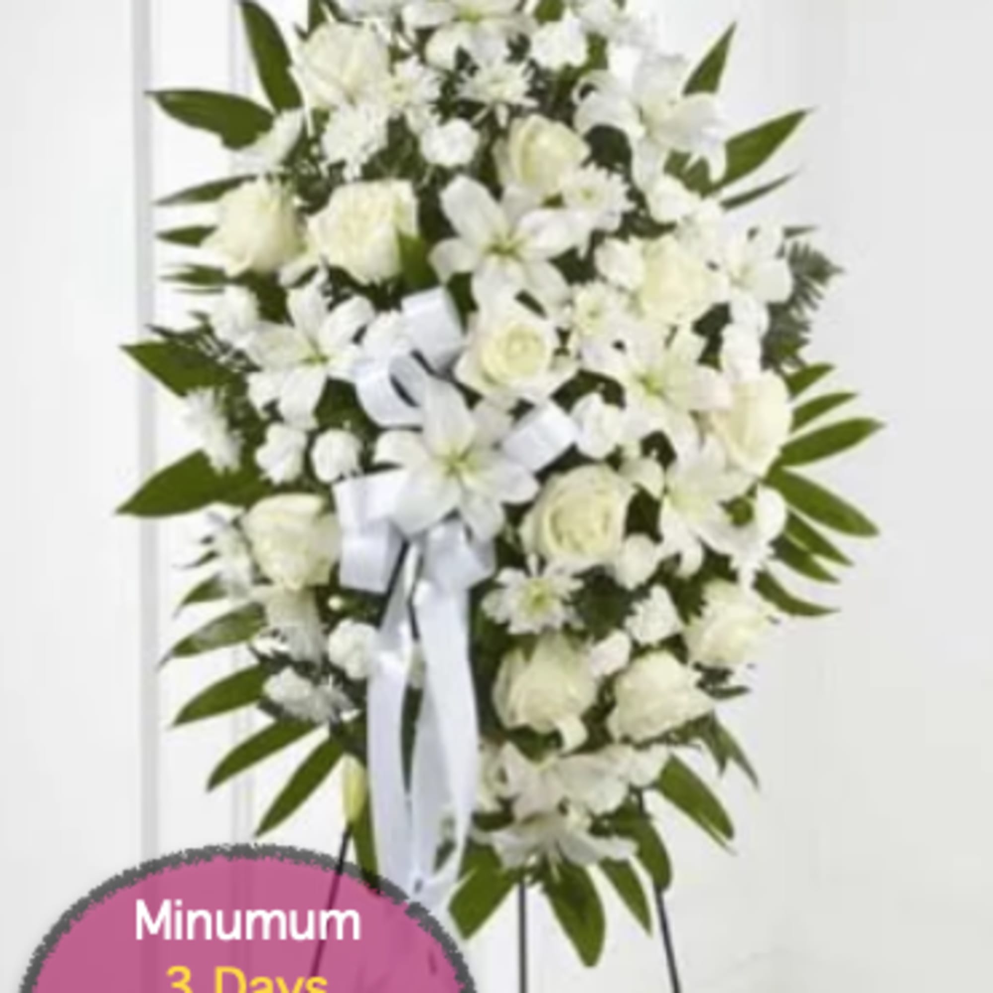 White funeral spray on a stand with ribbon