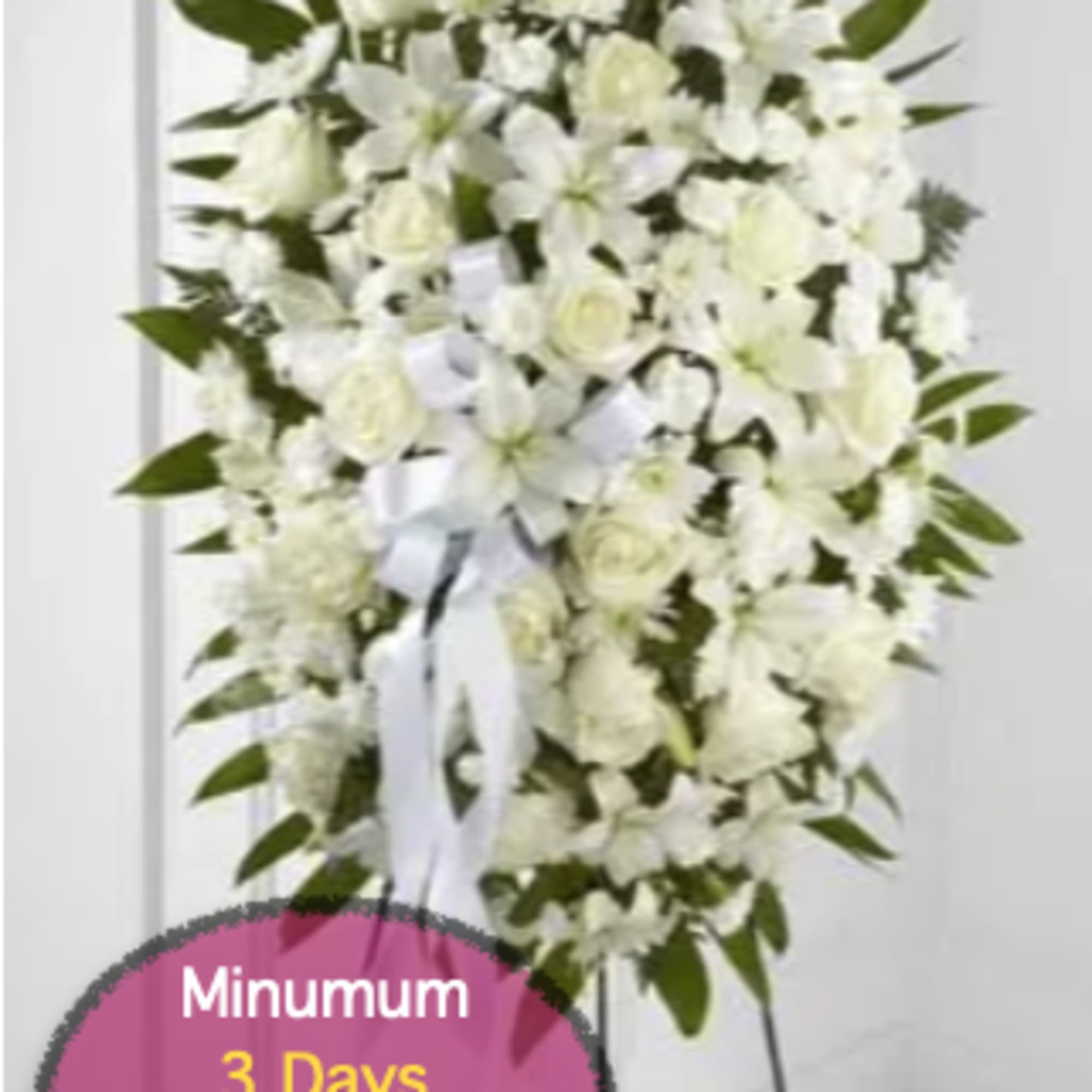 White funeral spray on a stand with ribbon