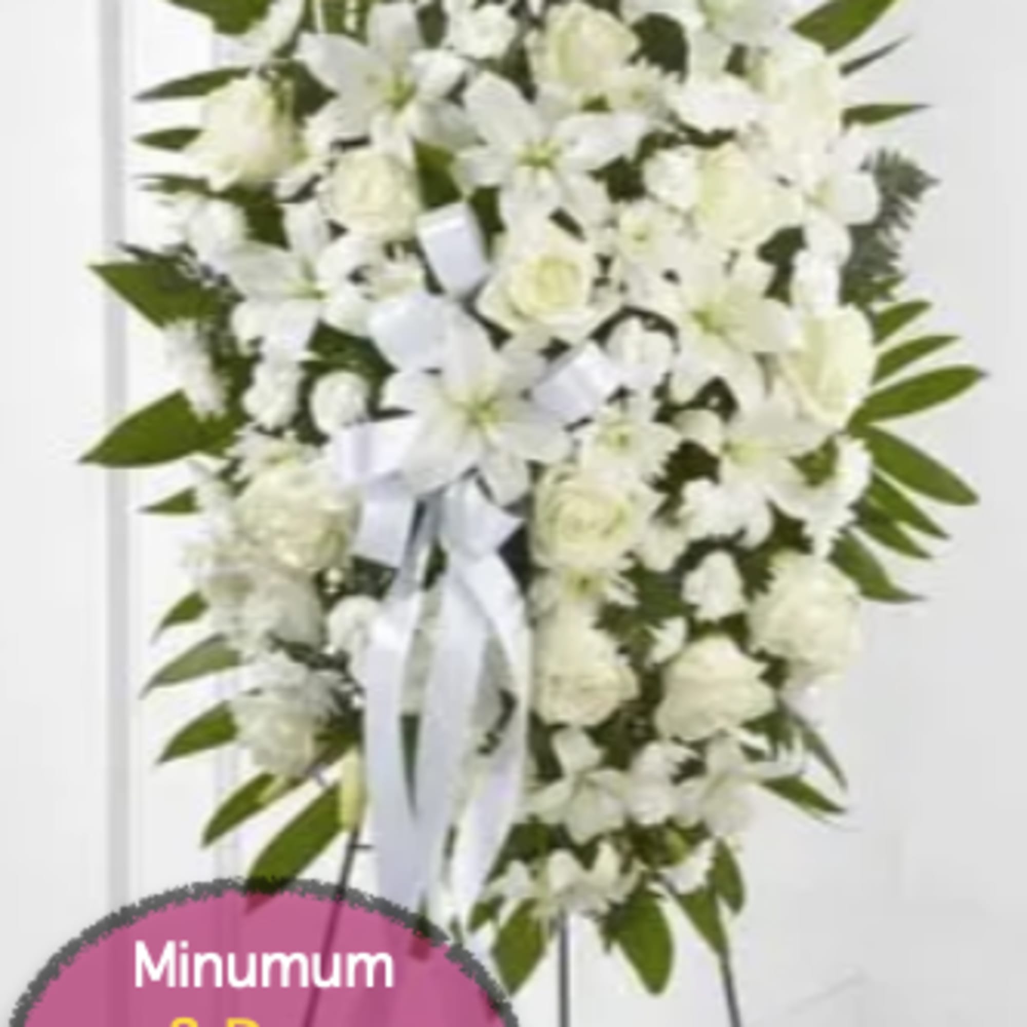Tall white floral standing spray on a metal easel with a ribbon