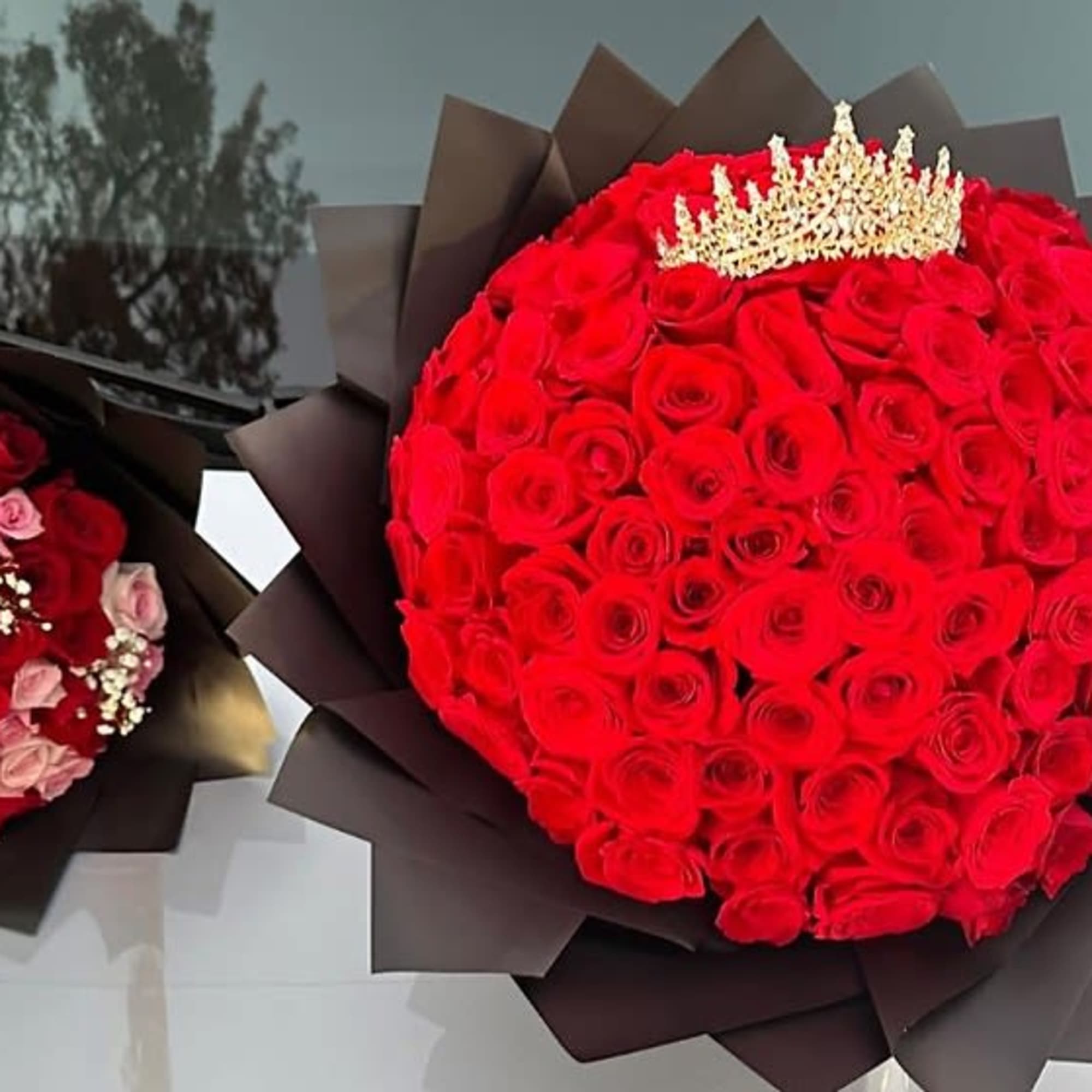 Two bouquets of red roses, one with pink roses and baby's breath