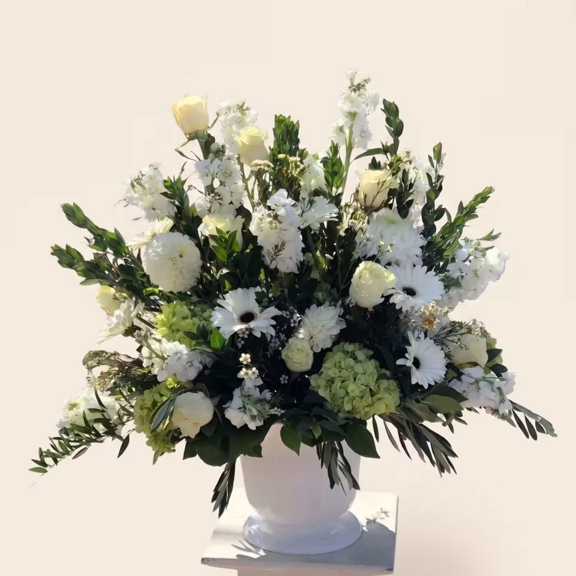 An elegant sympathy arrangement in a serene white and green palette. 

For