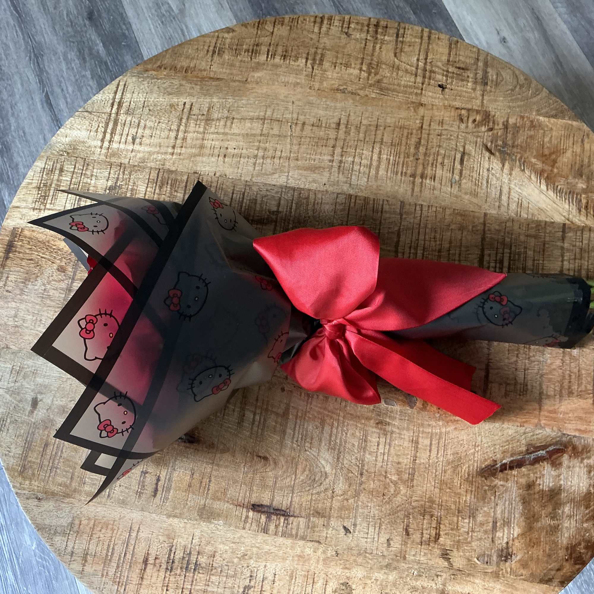 Wrapped bouquet tied with a red satin ribbon