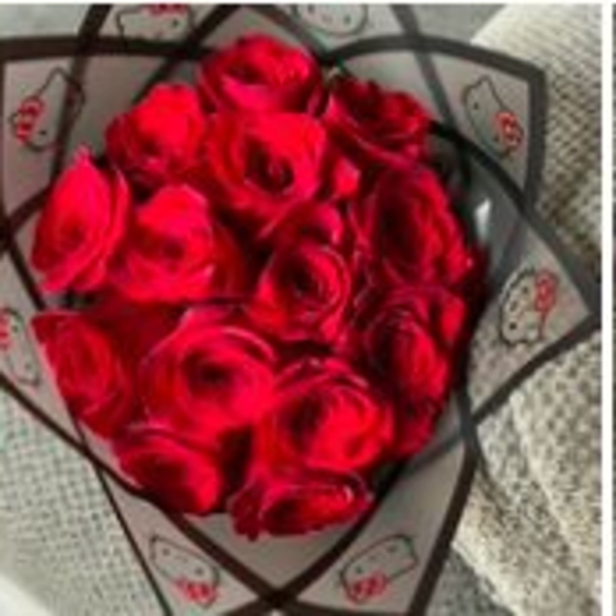 Bouquet of red roses wrapped in black paper with a red ribbon