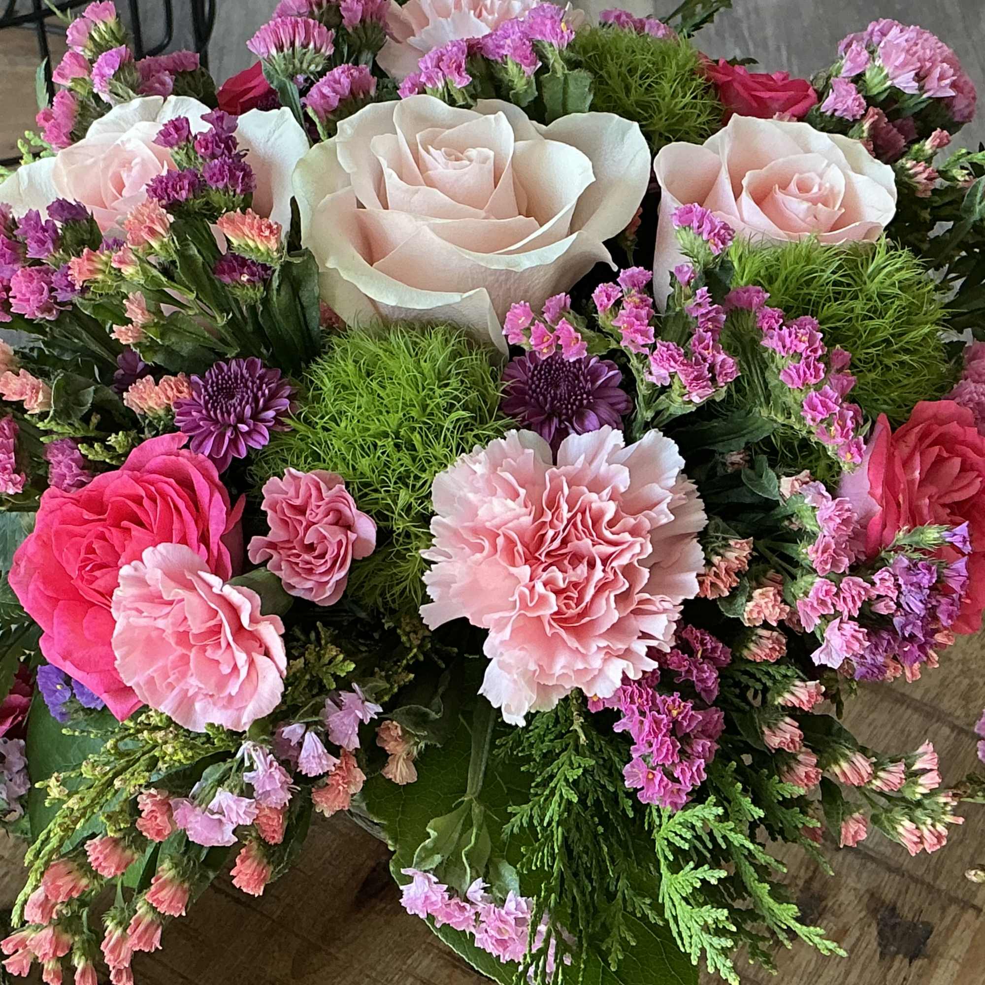Bouquet of pale pink roses and carnations with purple filler flowers