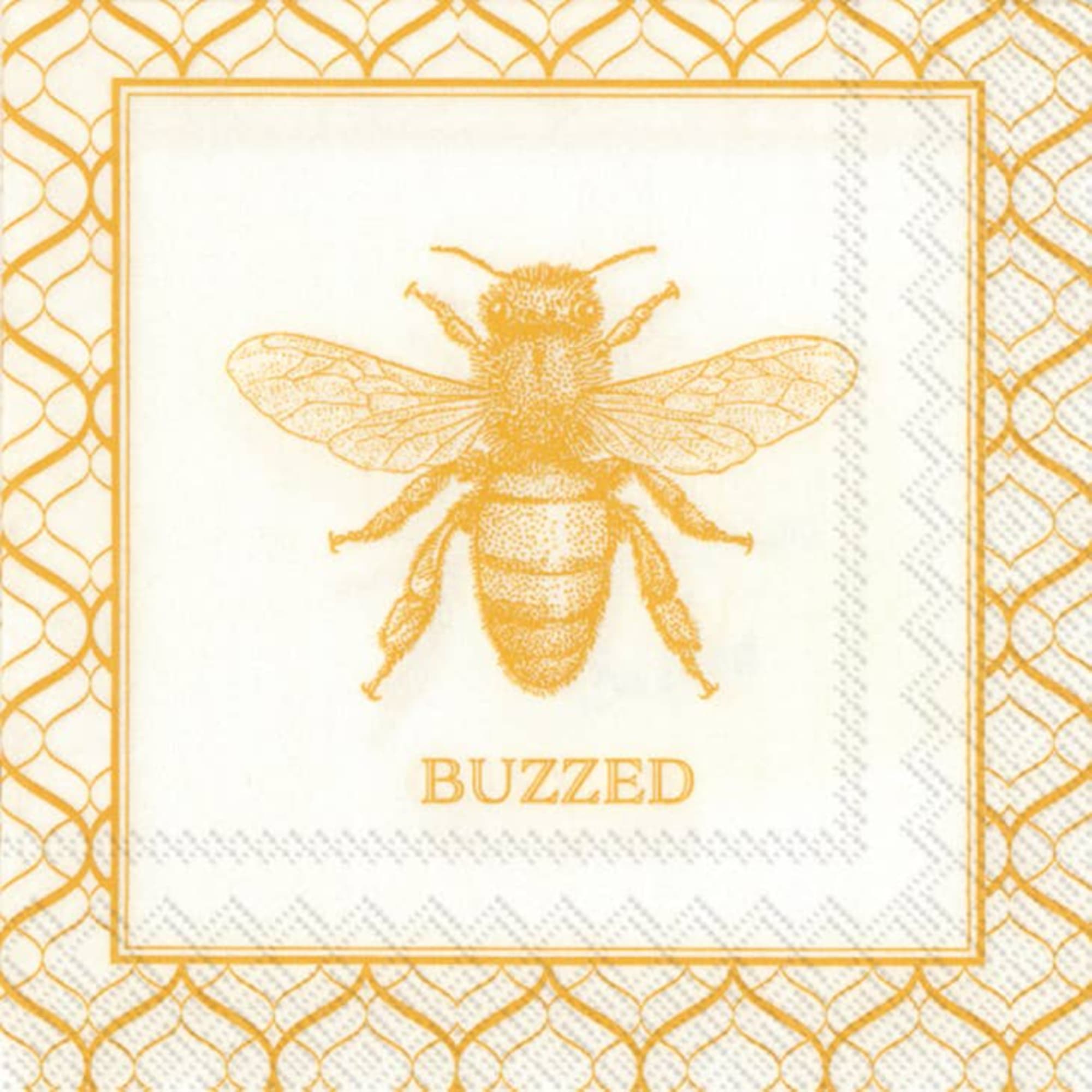 Gold bee illustration with the word "BUZZED" on a patterned napkin