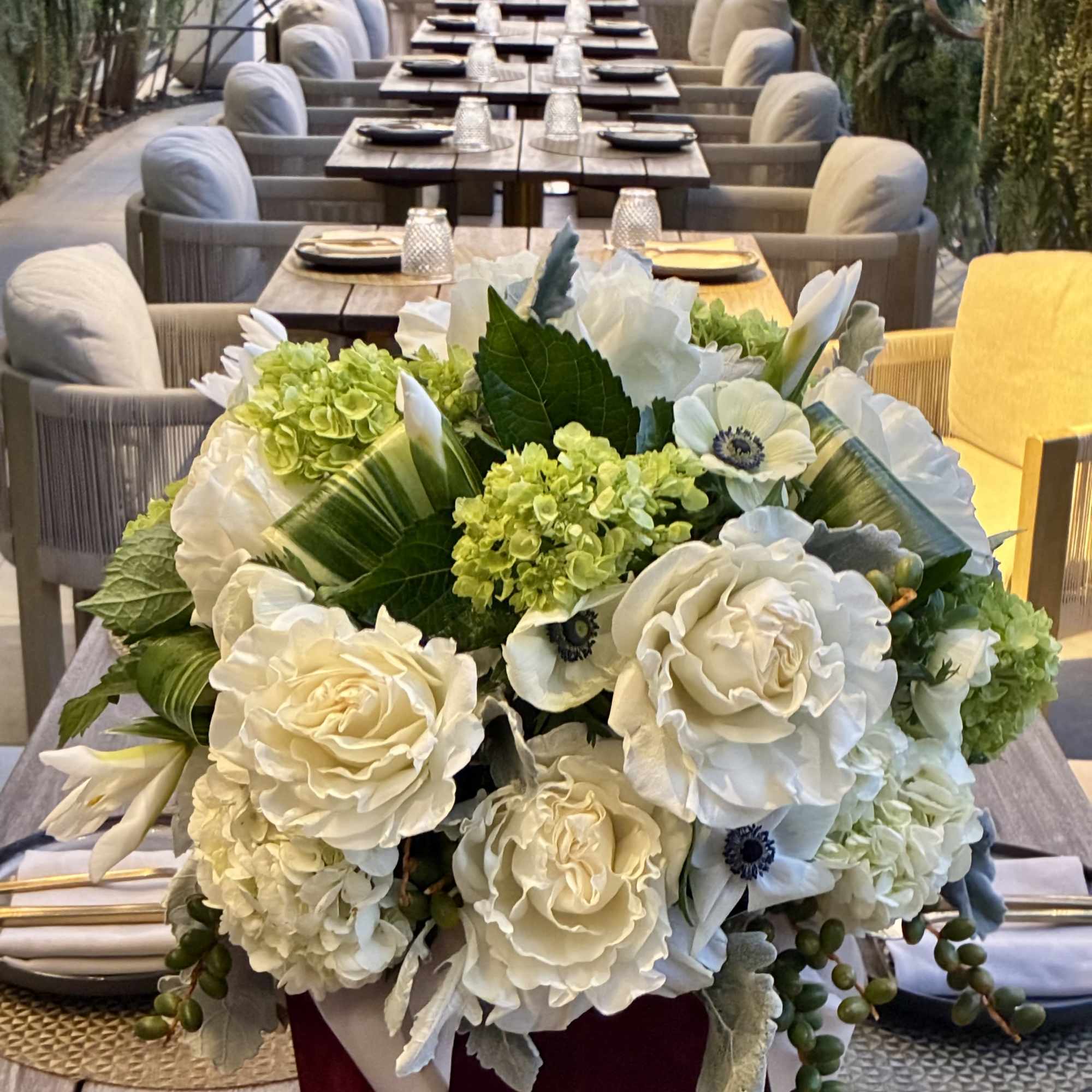 White floral centerpiece in a burgundy box on a dining table
