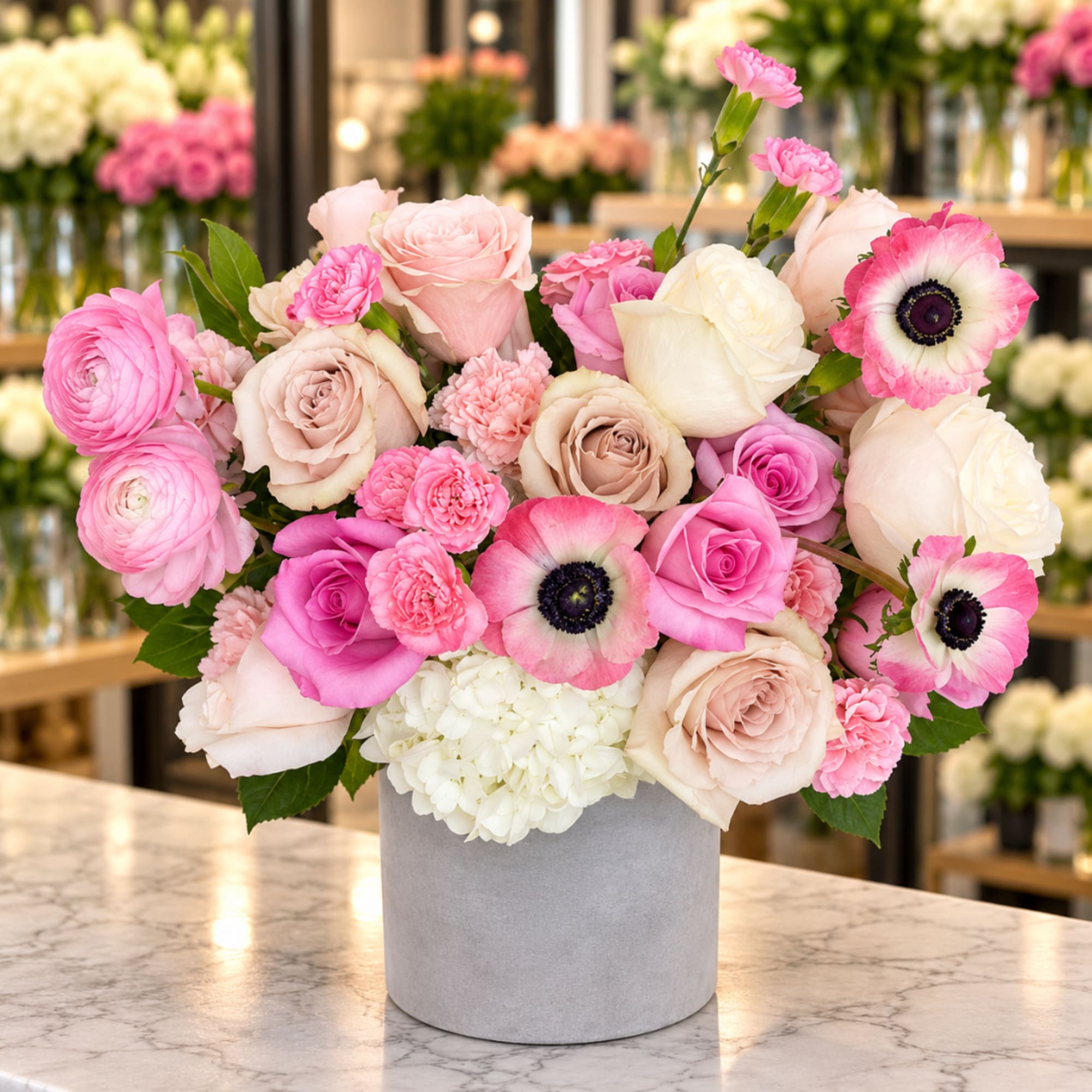 Pink and white roses with anemones in a gray vase