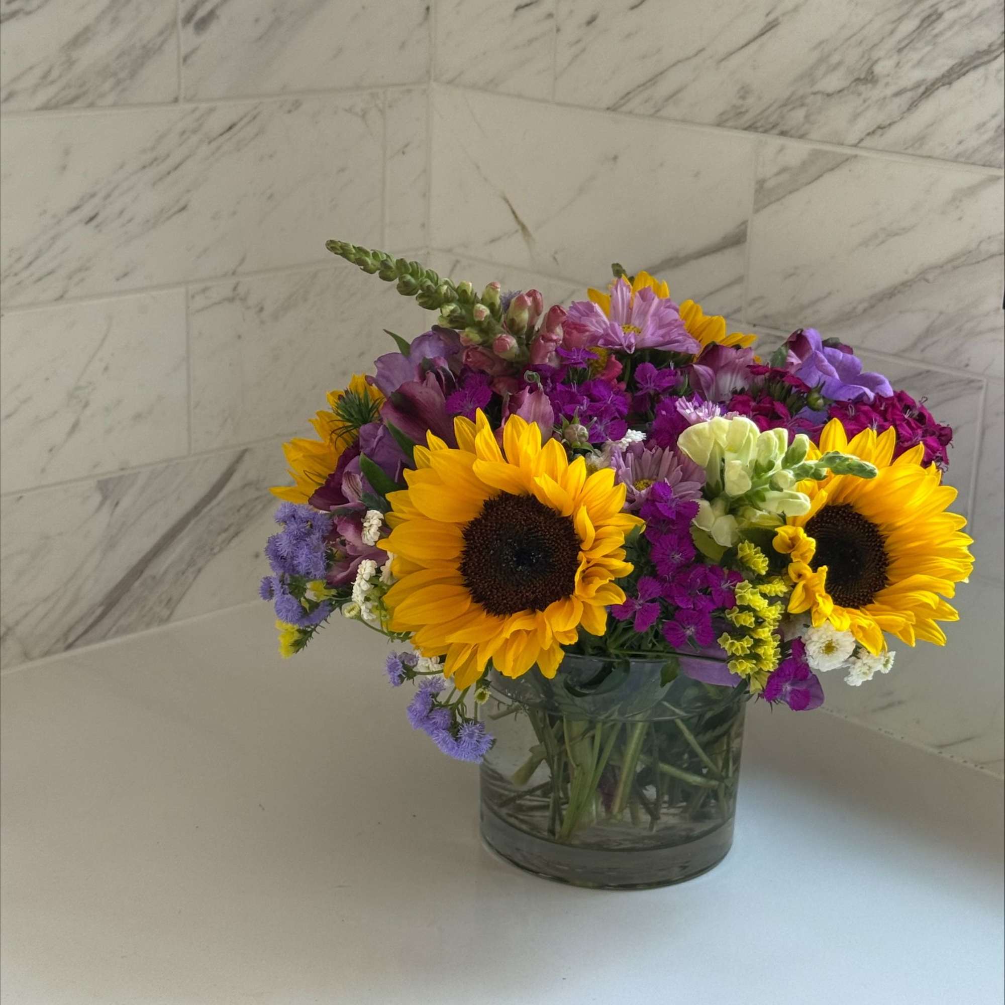 Mixed bouquet with sunflowers in a glass vase
