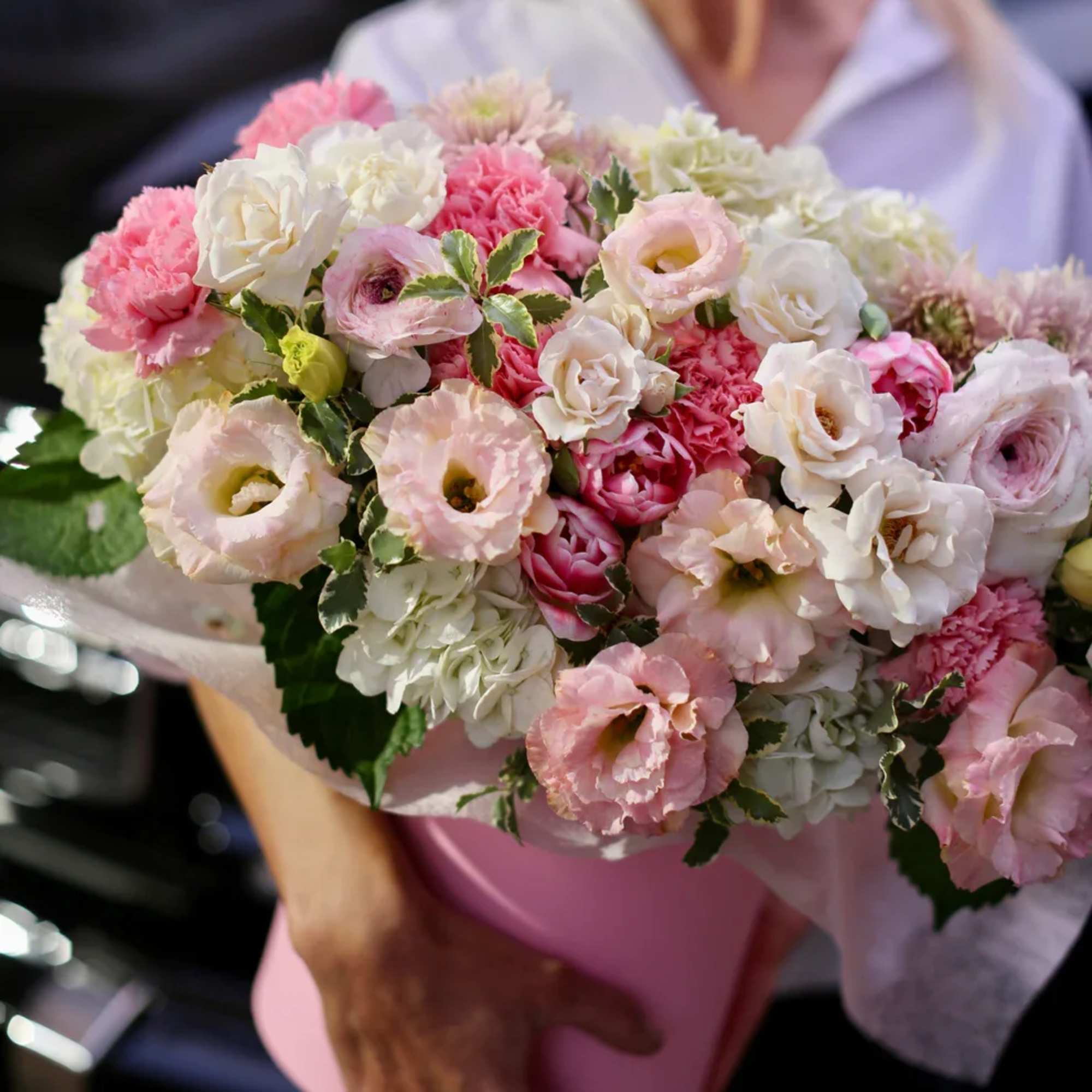 Bouquet of pink and white flowers wrapped in pale paper