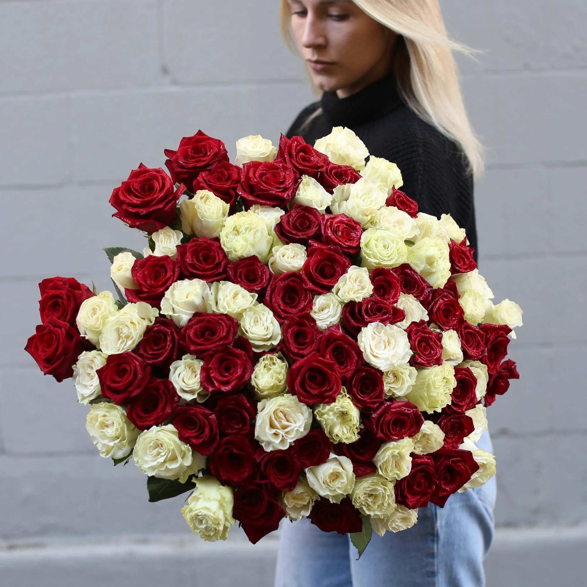Large bouquet of red and white roses held by a woman