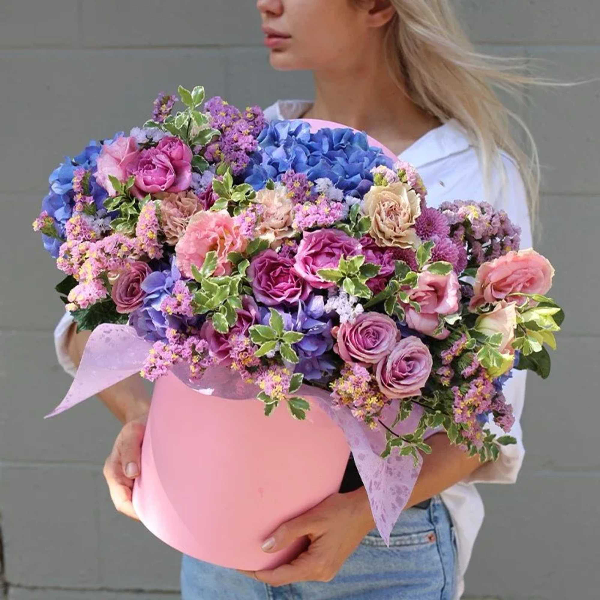 Large mixed bouquet in a pink hatbox with purple and blue flowers