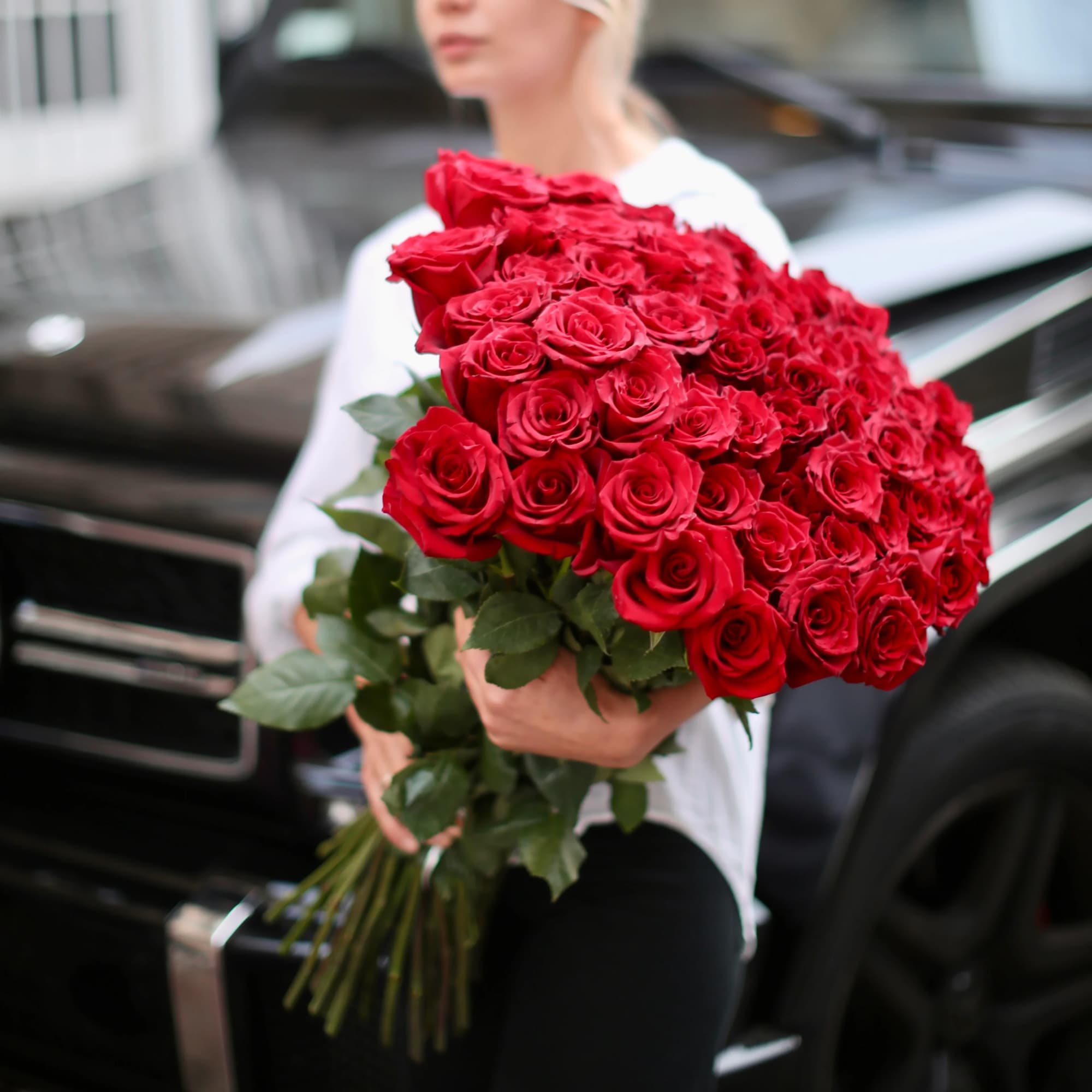 Large bouquet of red roses held by a person, photo 2 of 2