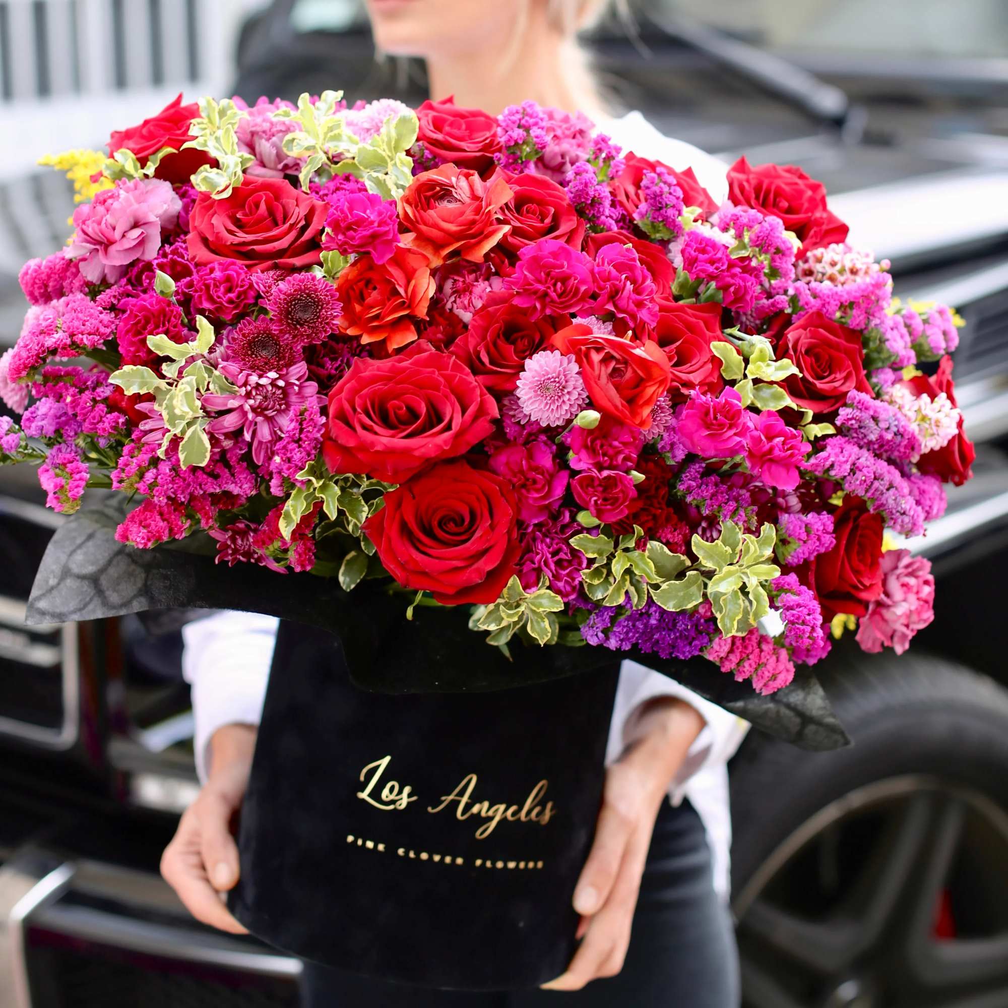Large bouquet of red and pink roses in a black box