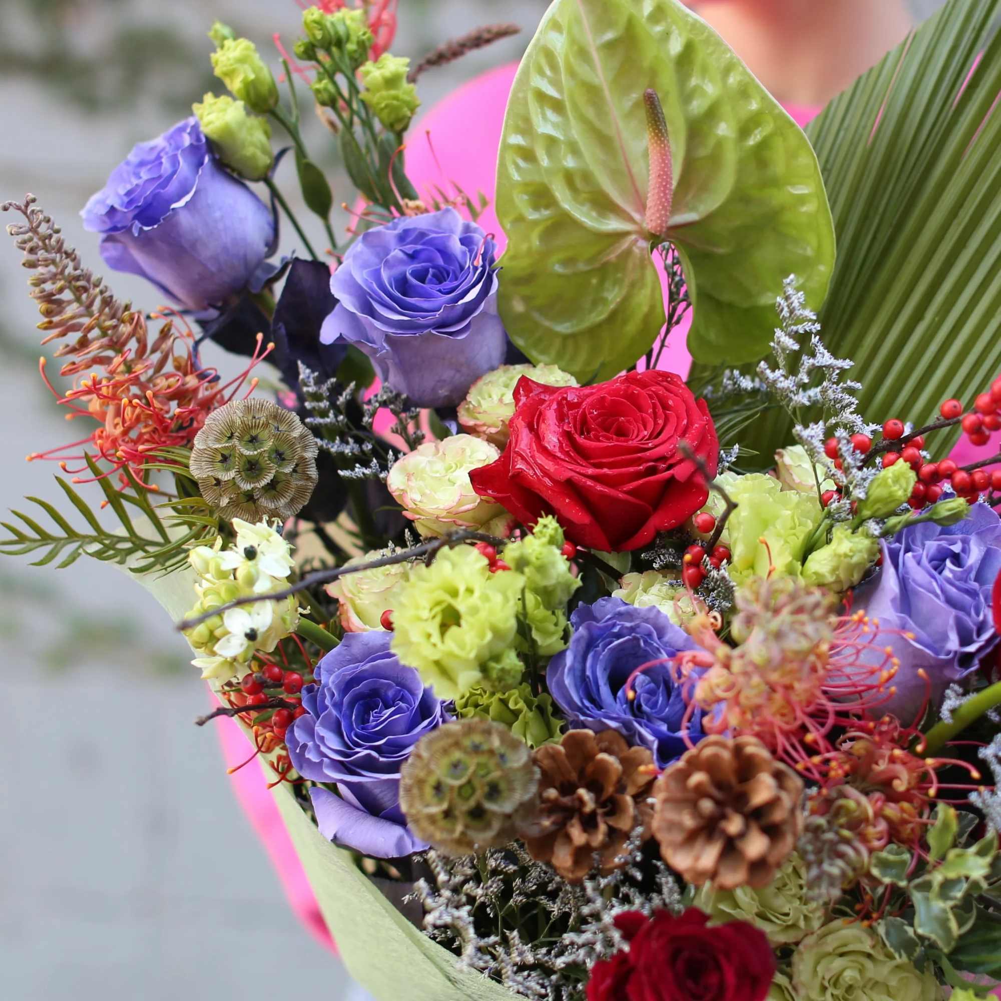 Bouquet of red and purple roses with green anthurium and mixed accents