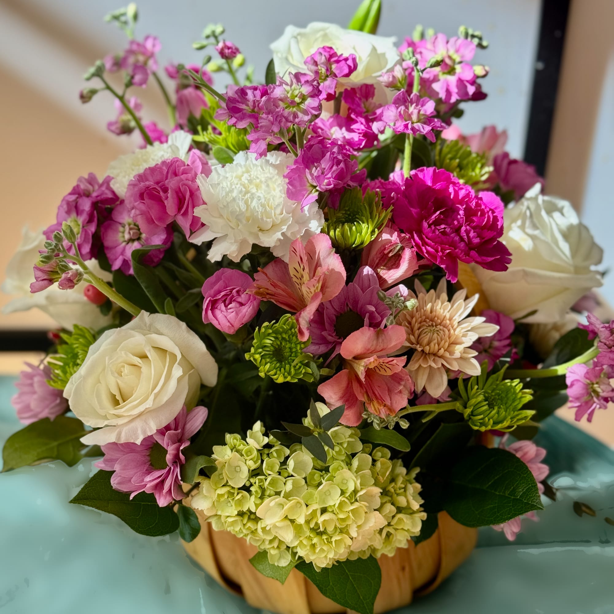Mixed pink and white flower arrangement in a pumpkin-shaped container