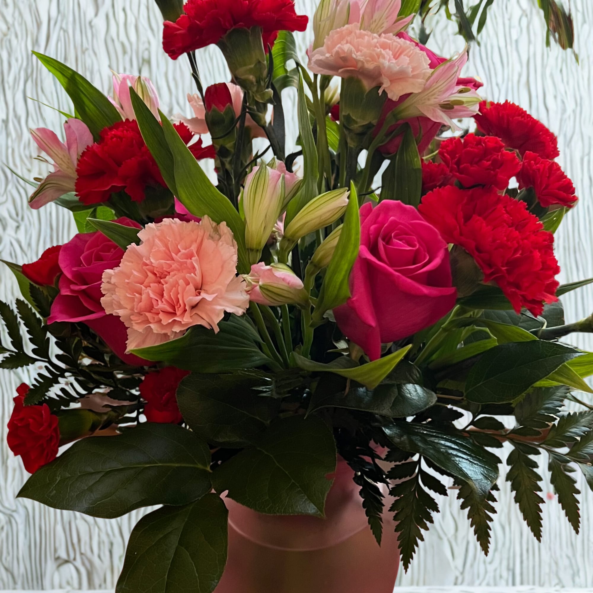 Pink and red mixed bouquet in a pink vase