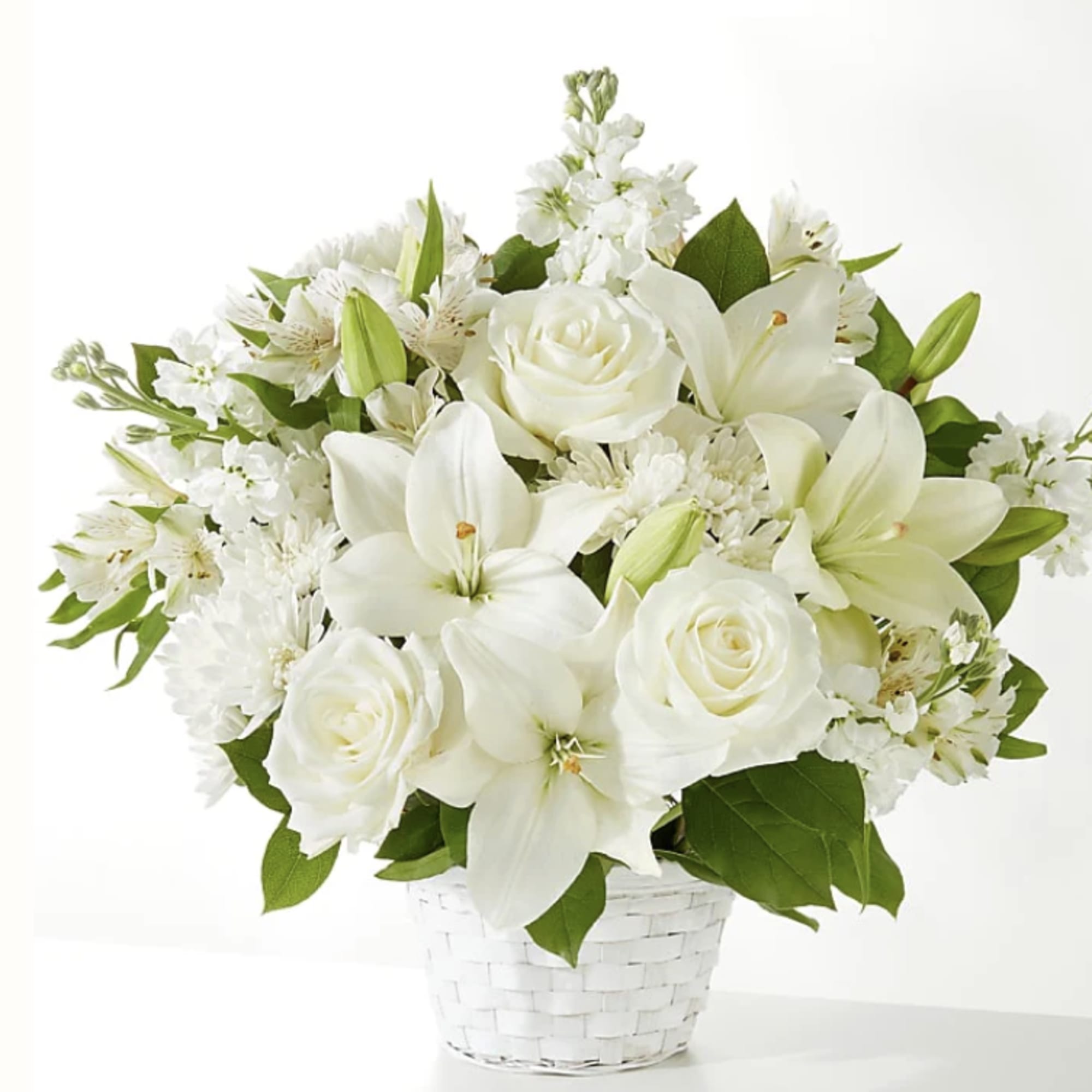 White lilies and roses in a white woven basket