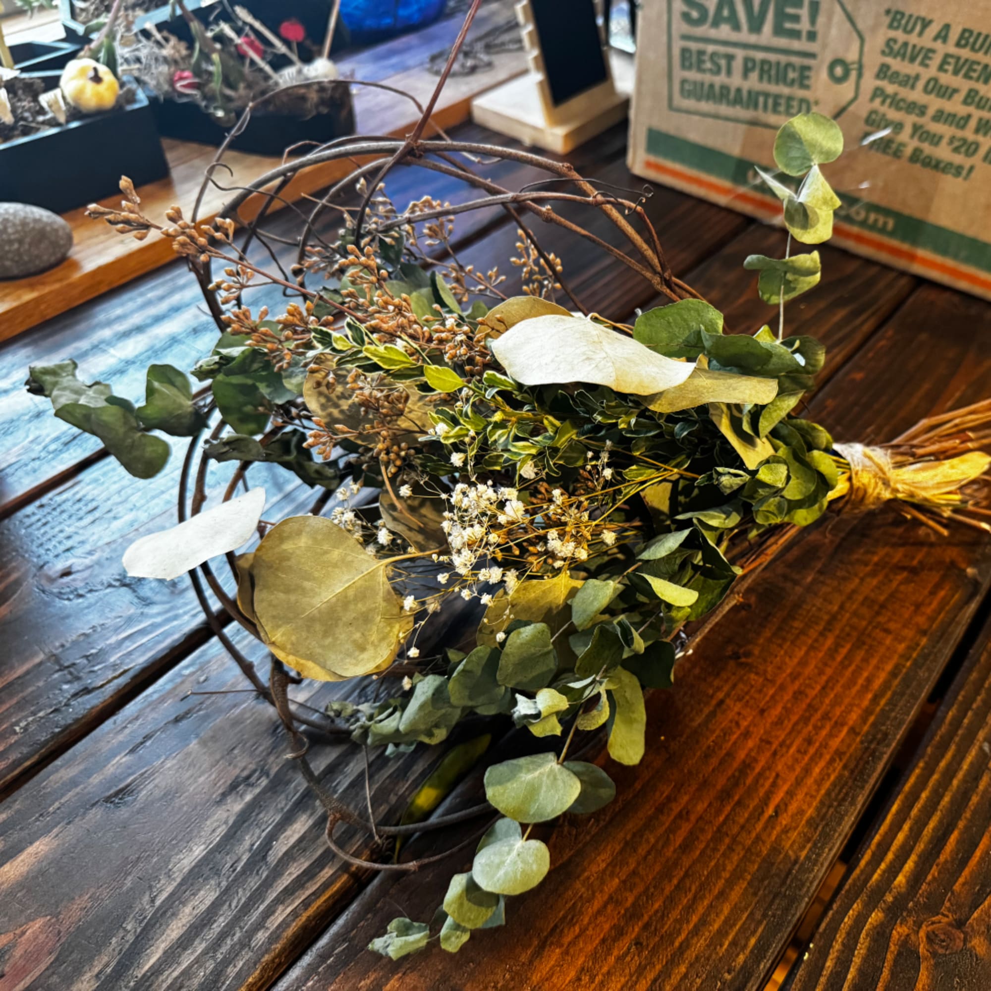 Loose greenery bouquet with eucalyptus and dried accents on a wooden table