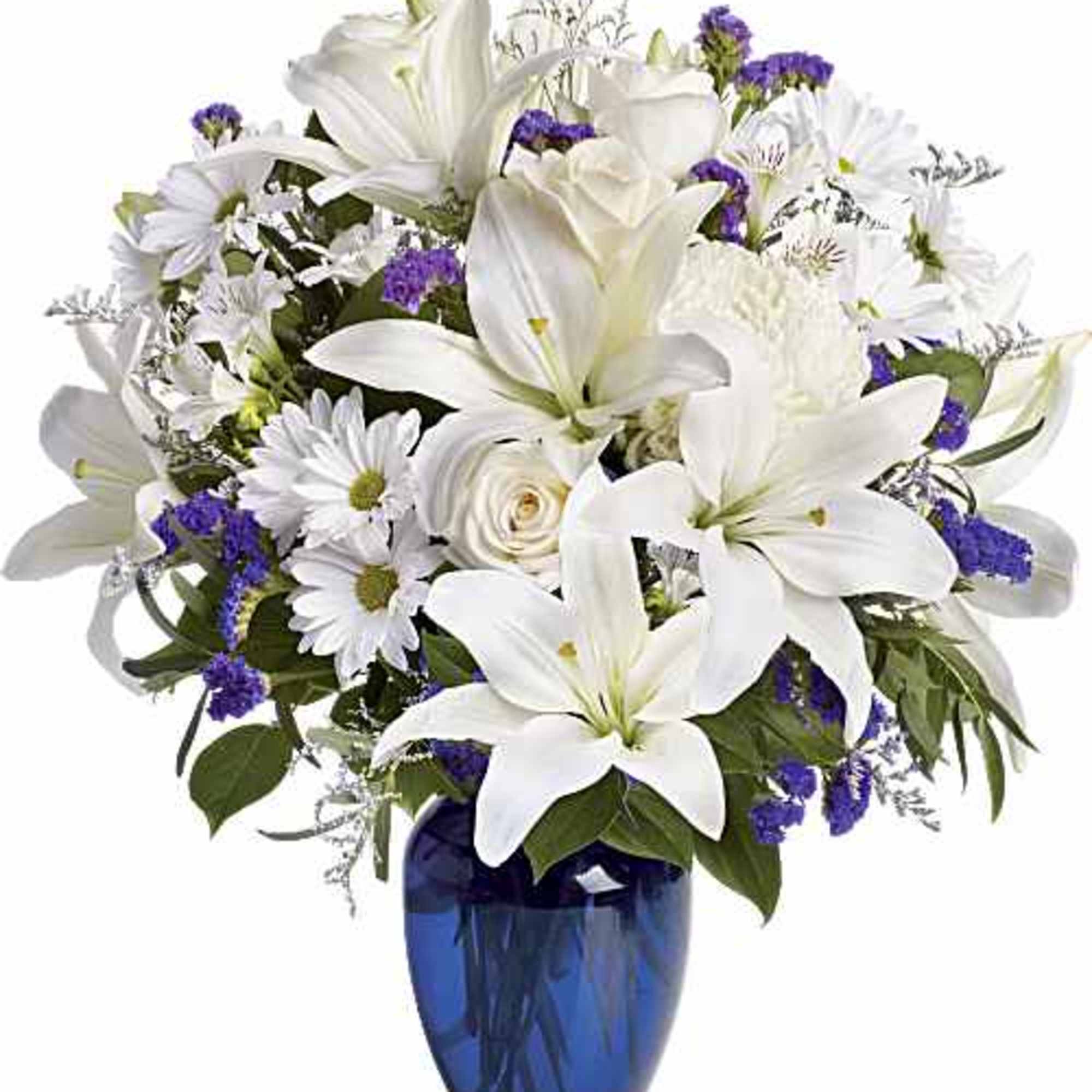 White lilies and daisies in a blue glass vase