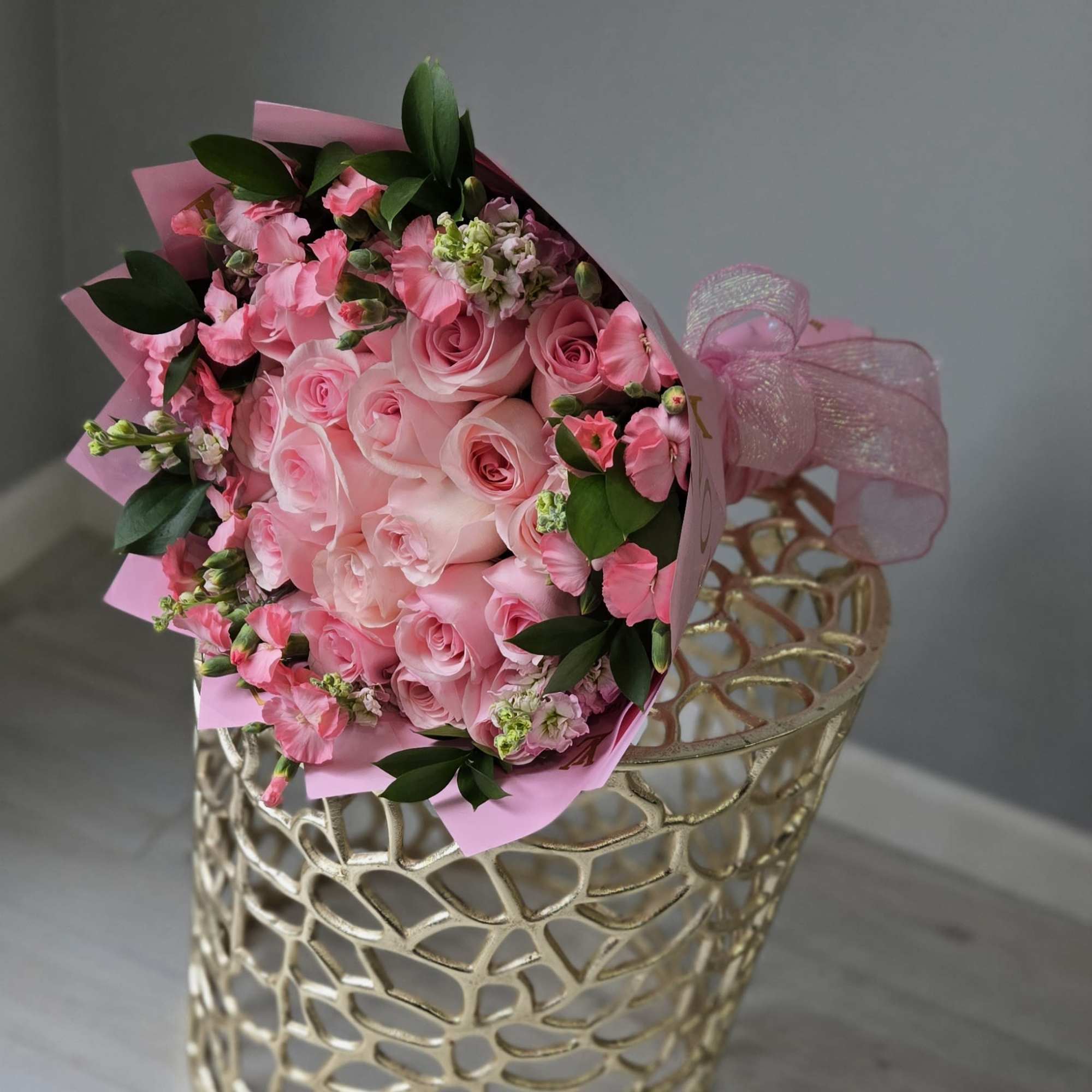 Pink rose bouquet with small pink flowers in a gold lattice vase
