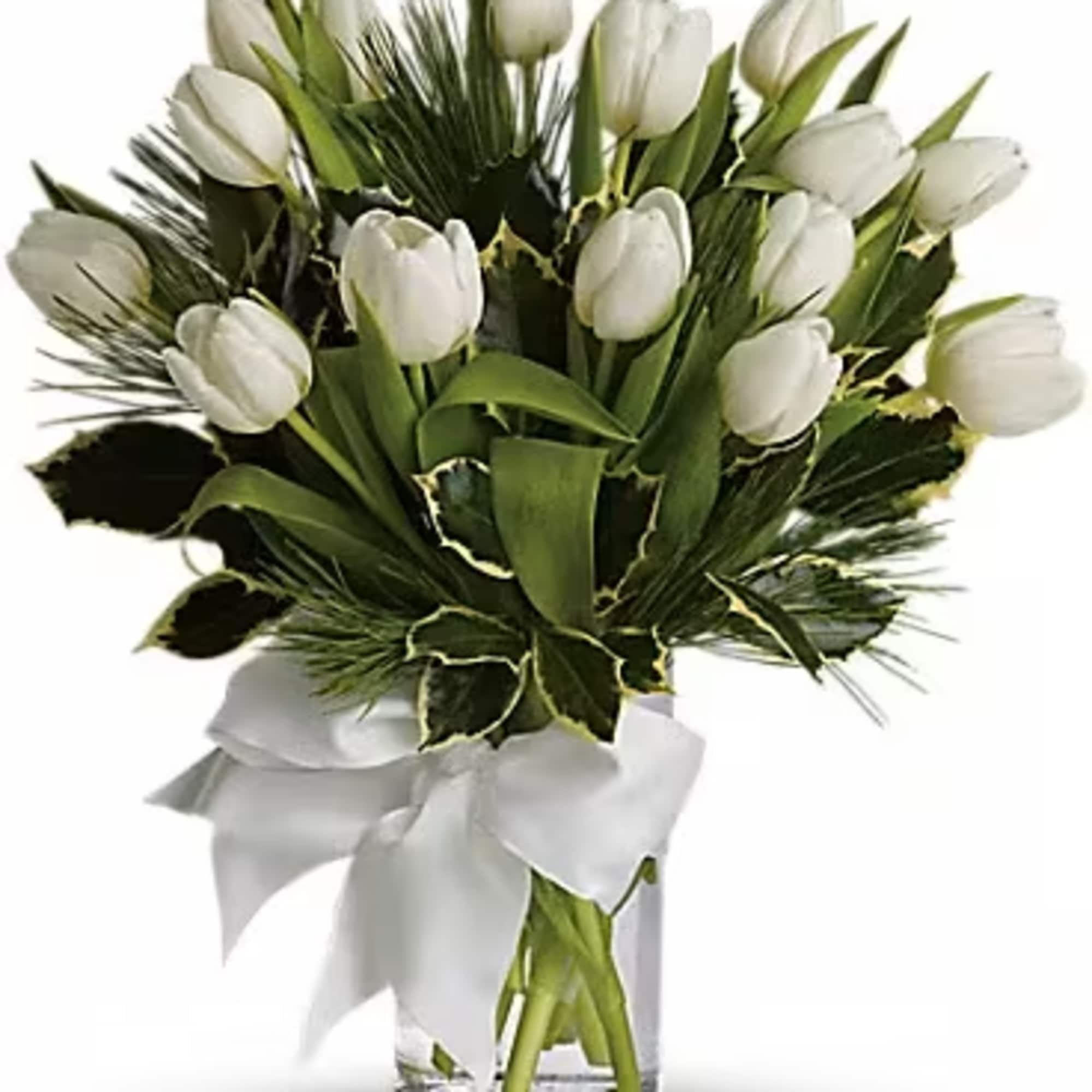 White tulip bouquet in a clear glass vase with a white ribbon
